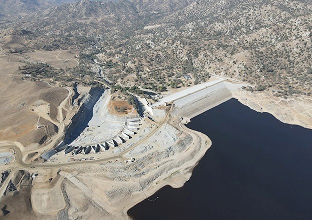 Aerial photograph of a dam surrounded by a barren landscape. 