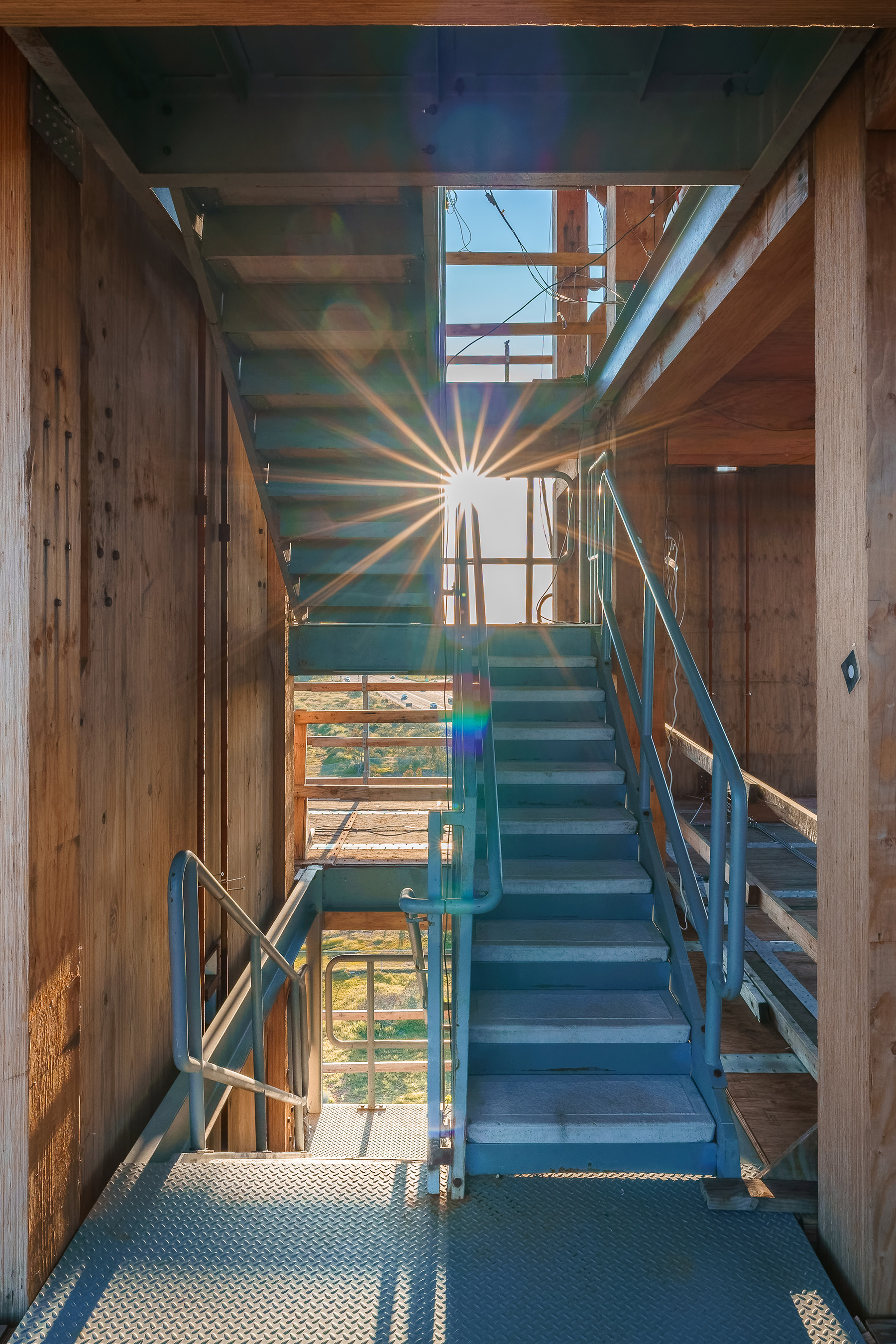 A blue staircase sits inside a wooden structure.