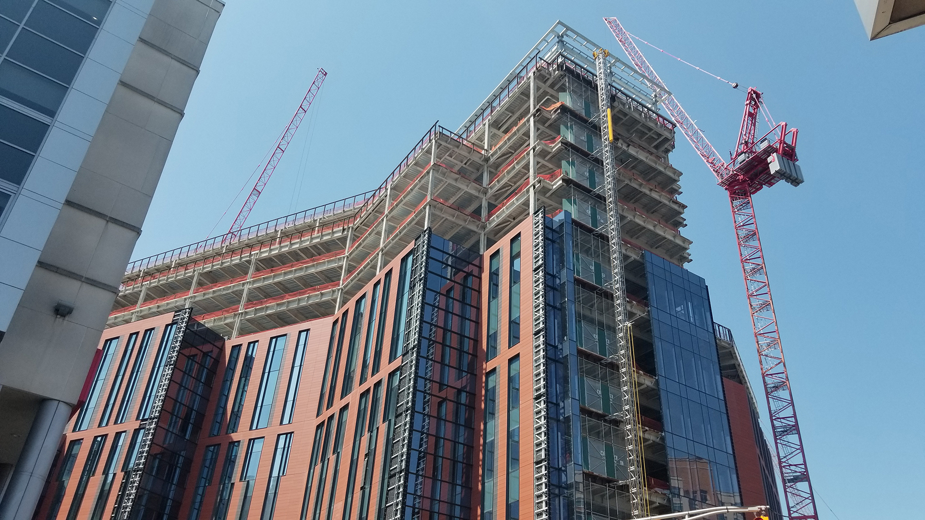 The design features a largely glazed, metal panel facade that steps back repeatedly. (Photograph courtesy O’Donnell & Naccarato)