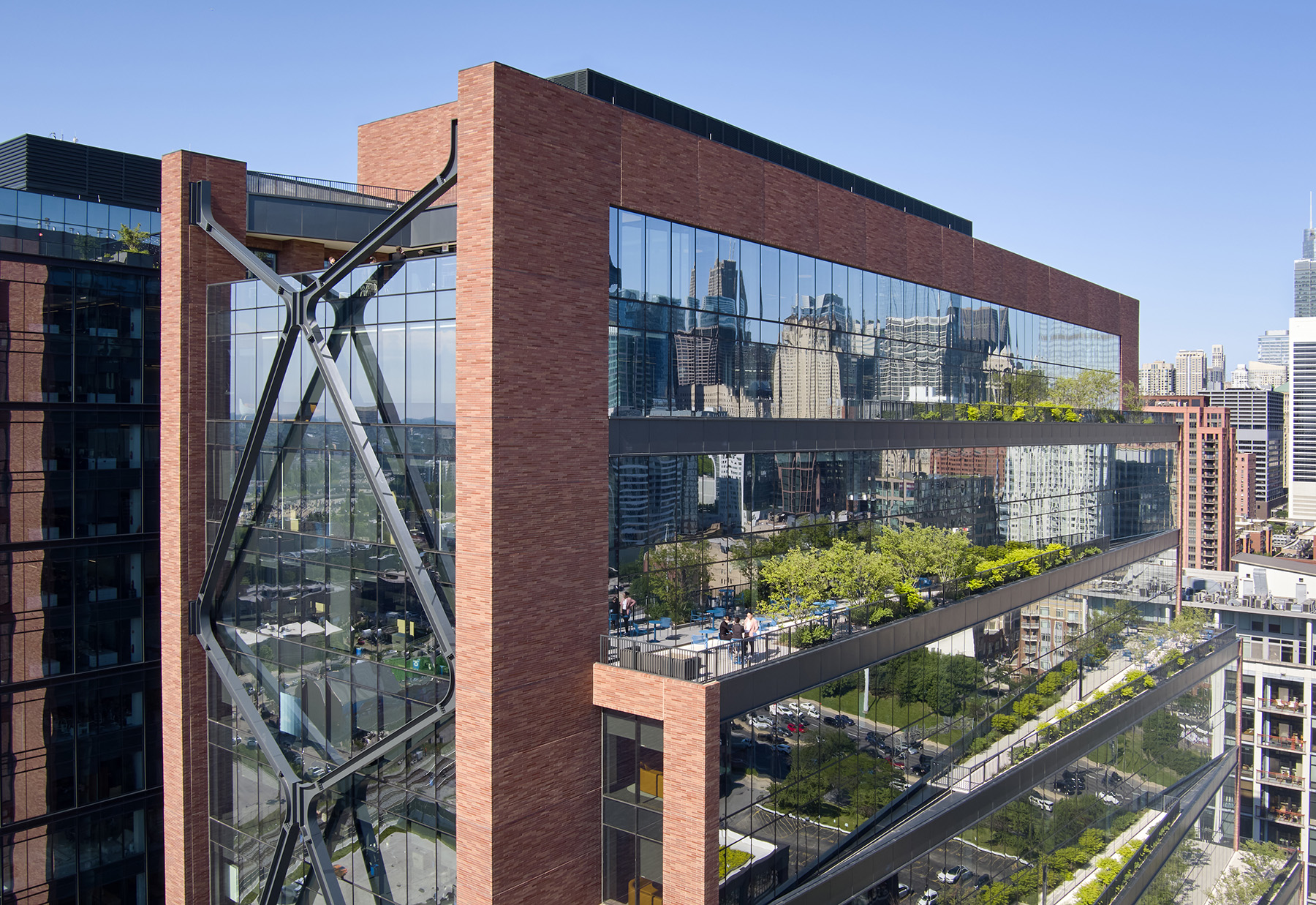 A large multistory, brick, glass, steel, and concrete structure is shown. 