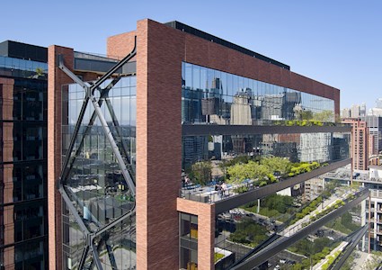 A large multistory, brick, glass, steel, and concrete structure is shown. 