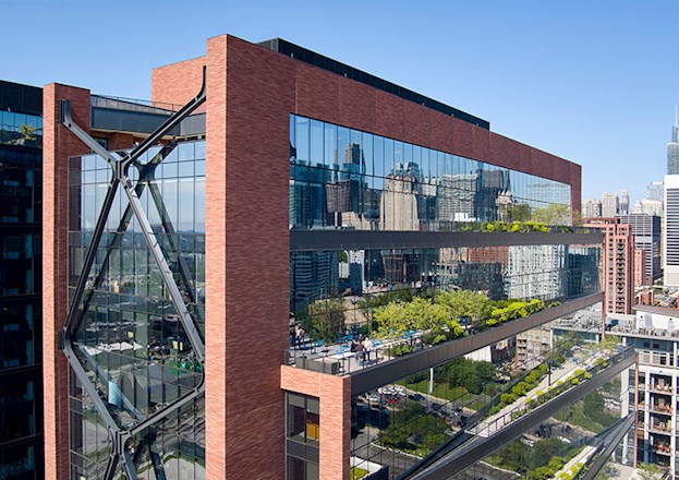 A large multistory, brick, glass, steel, and concrete structure is shown.