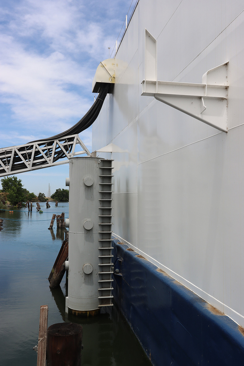 Image shows a permanent guide mooring attached to a structure floating in water. 