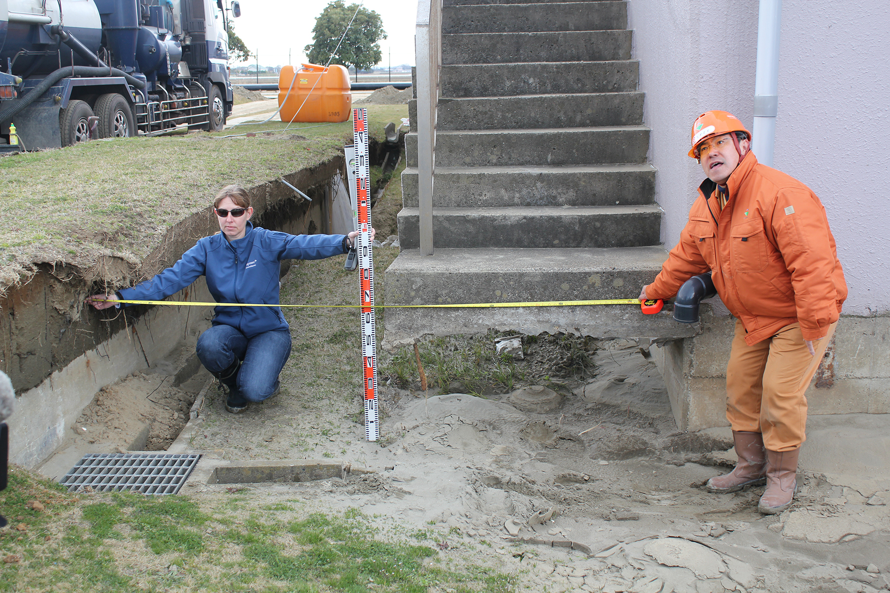 Nearly 3 ft of settlement occurred at this water purification plant in Japan after the 2011 Tohoku earthquake. Measuring the damage are Jennifer L. Donahue, Ph.D., P.E., M.ASCE, a member of the Geotechnical Extreme Events Reconnaissance team from the National Science Foundation, and an engineer from the Wanigawa Water Purification Plant. (Photo by Scott Ashford, courtesy of Oregon State University) 