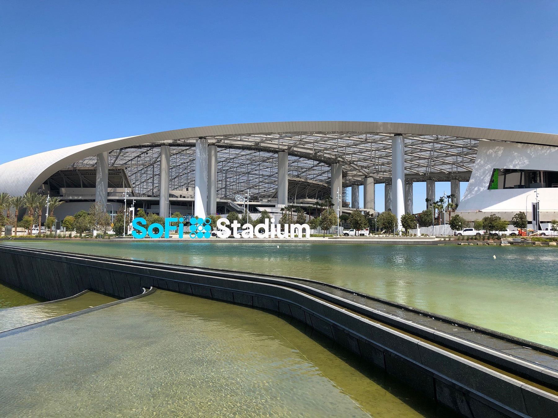 Image shows a large, multistory building with a steel-latticed roof. 