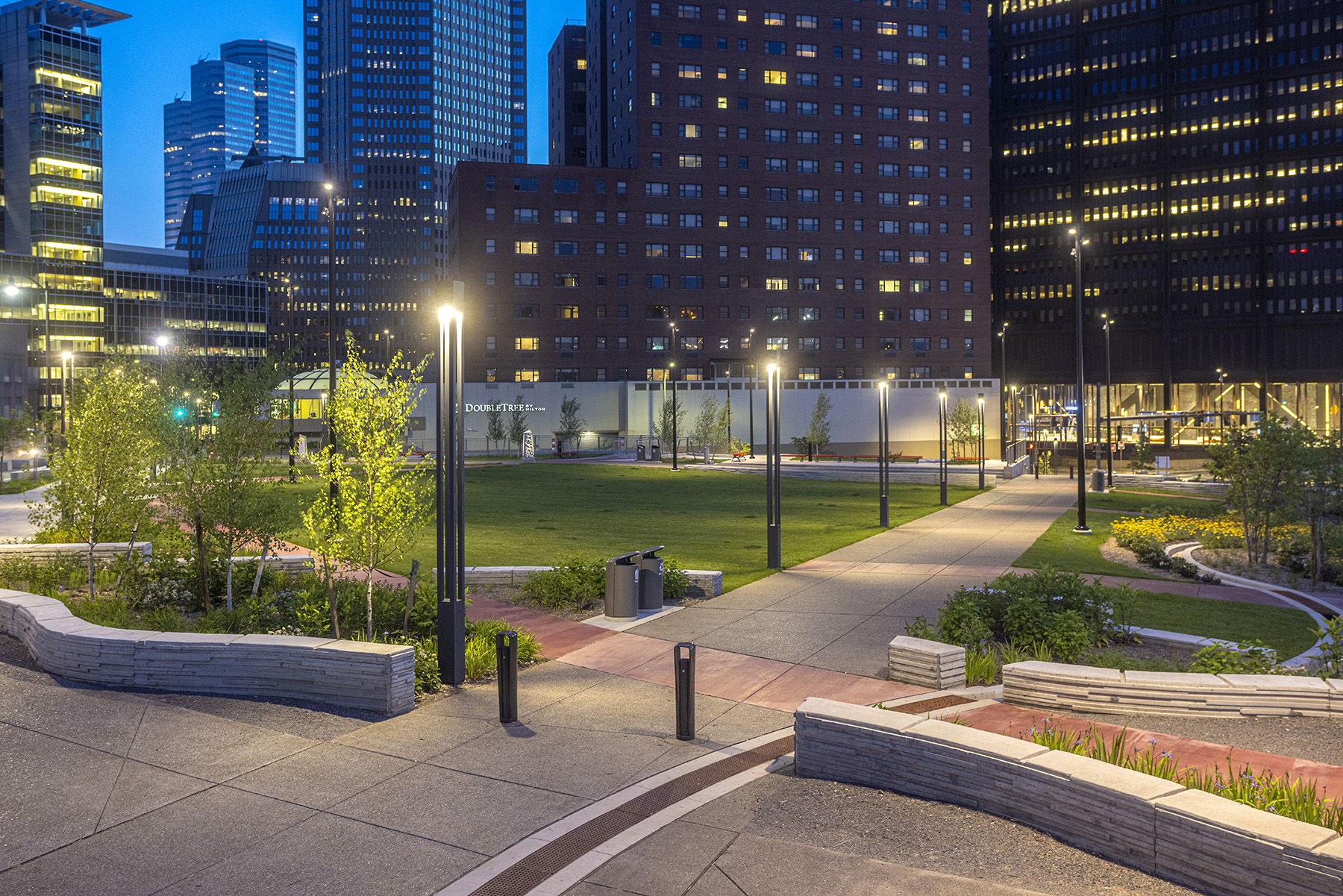 A green space with trees, benches, and paths is shown.