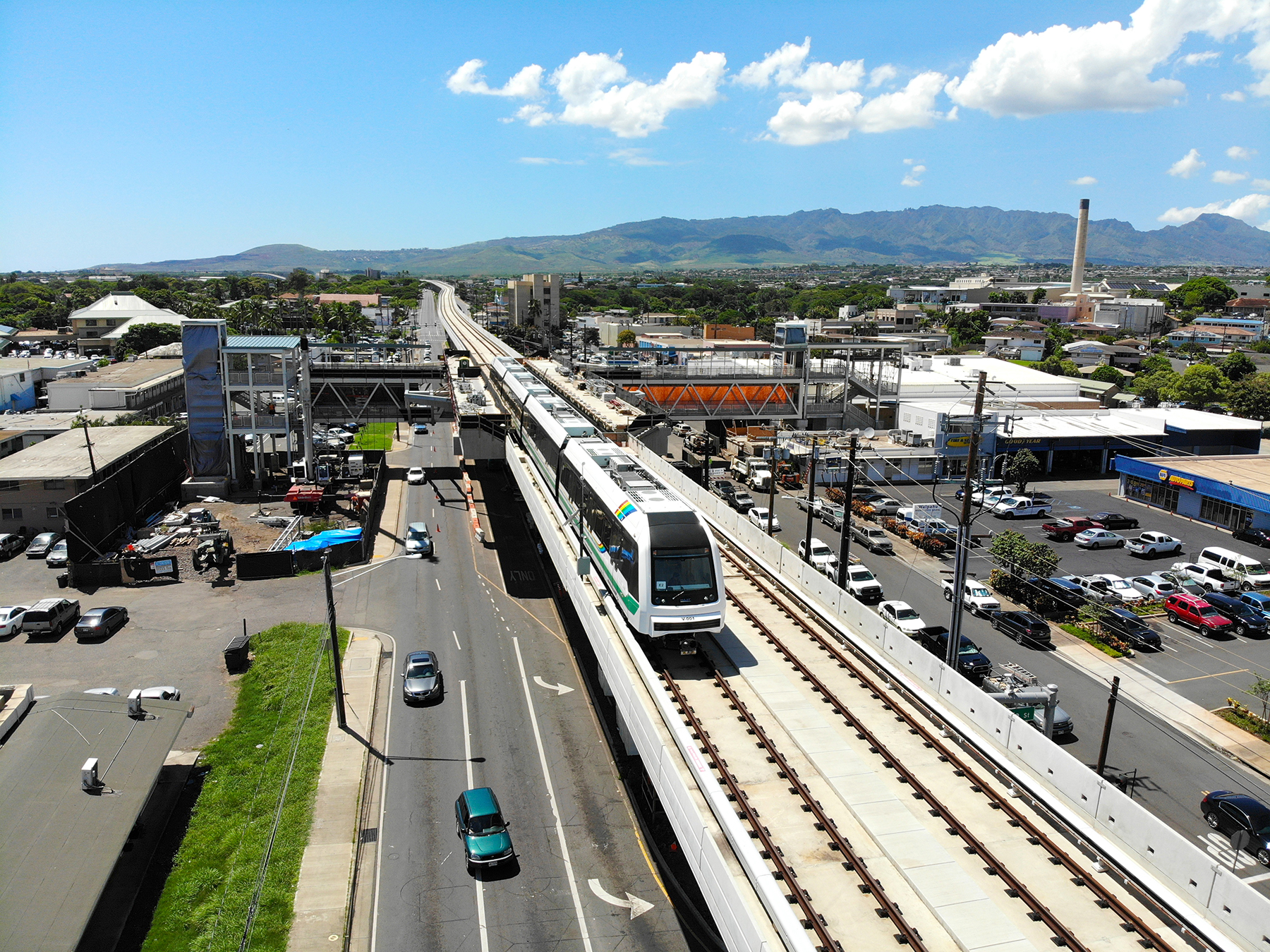 The elevated guideway measures approximately 30 ft wide to accommodate two sets of tracks. Shown here, a train stops at the Pouhala/Waipahu Transit Center. (Image courtesy of HART)