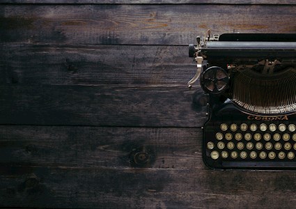 ANTIQUE TYPEWRITER ON WOODEN DESK