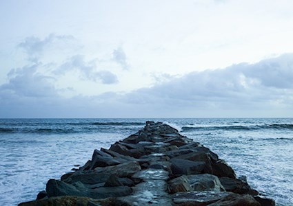 Breakwater built of rocks surrounded by waters