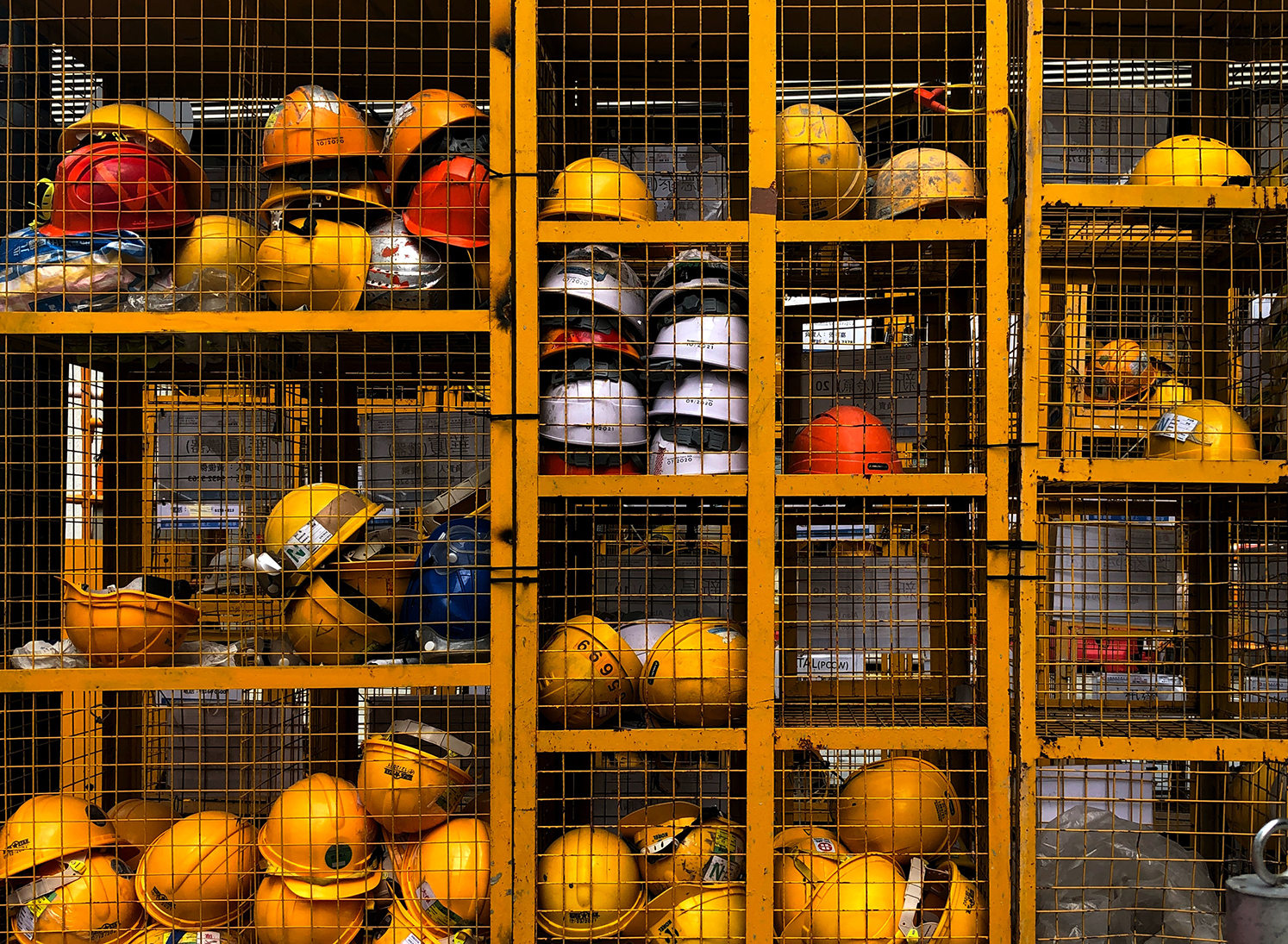 HARDHATS IN CAGE (Photo by Pop & Zebra on Unsplash)