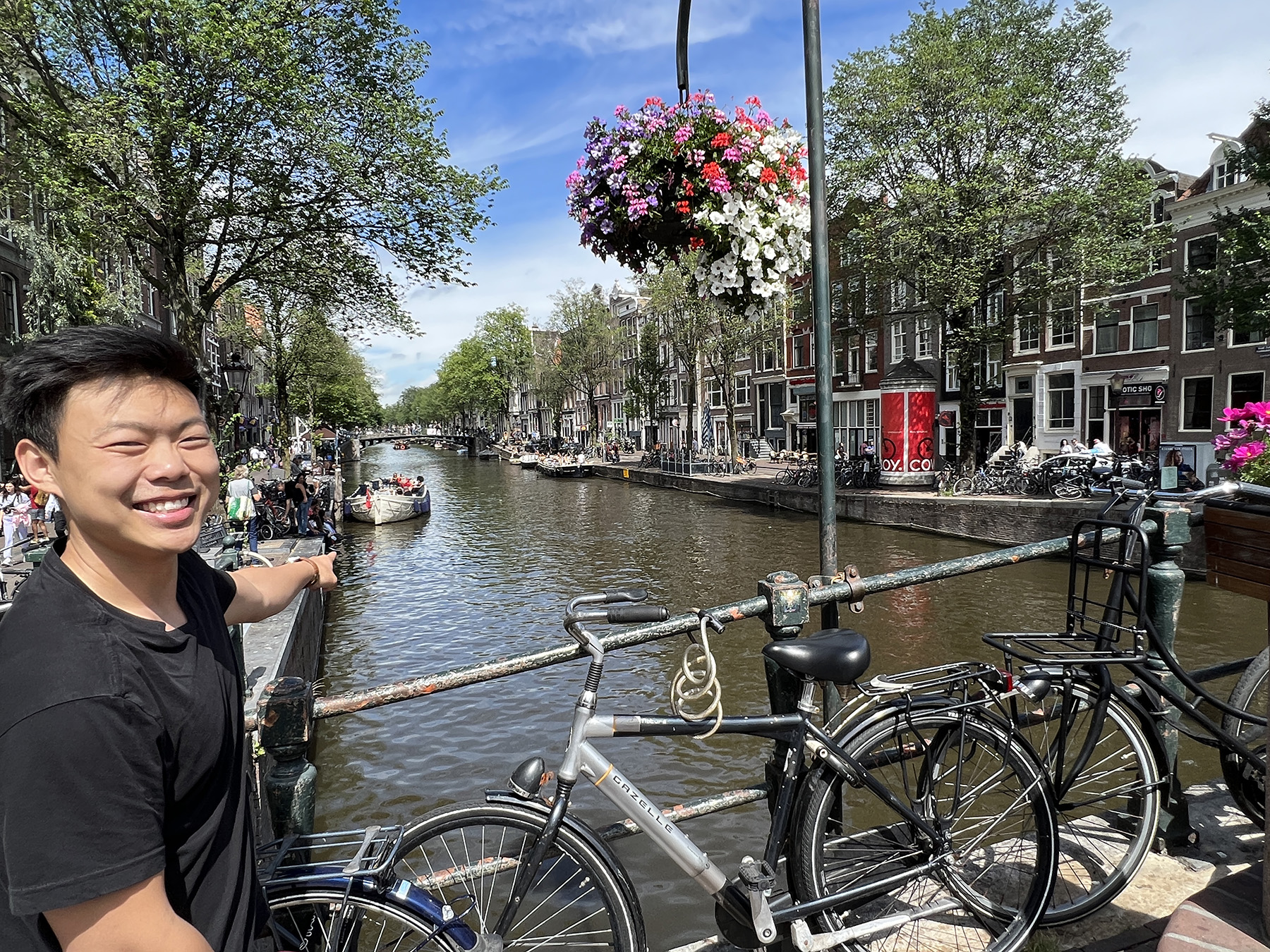 The photograph shows civil engineer Paul Lee pointing to a canal in Amsterdam, surrounded by bicycles. 