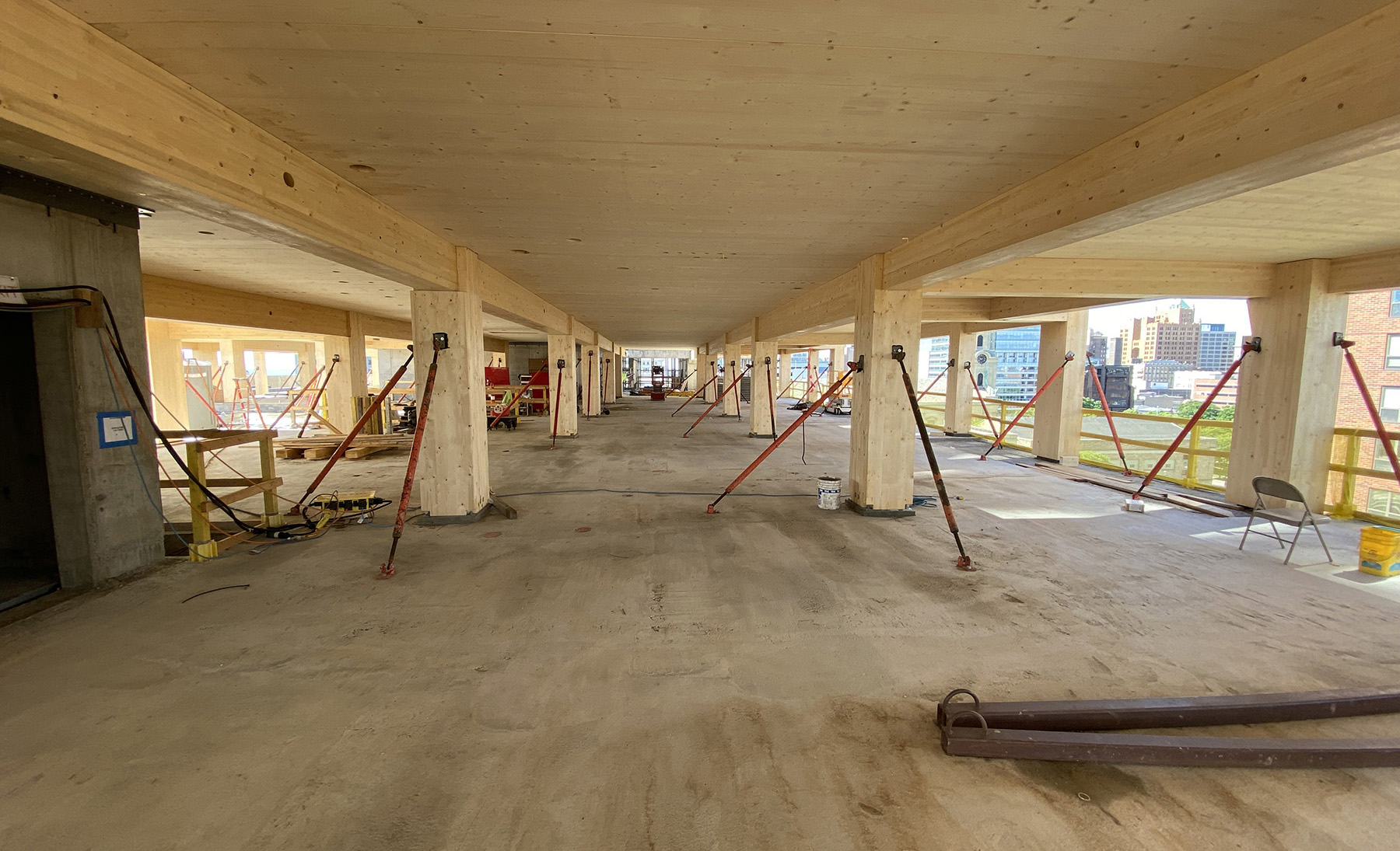 Photograph shows the wood beams and floor framing. 