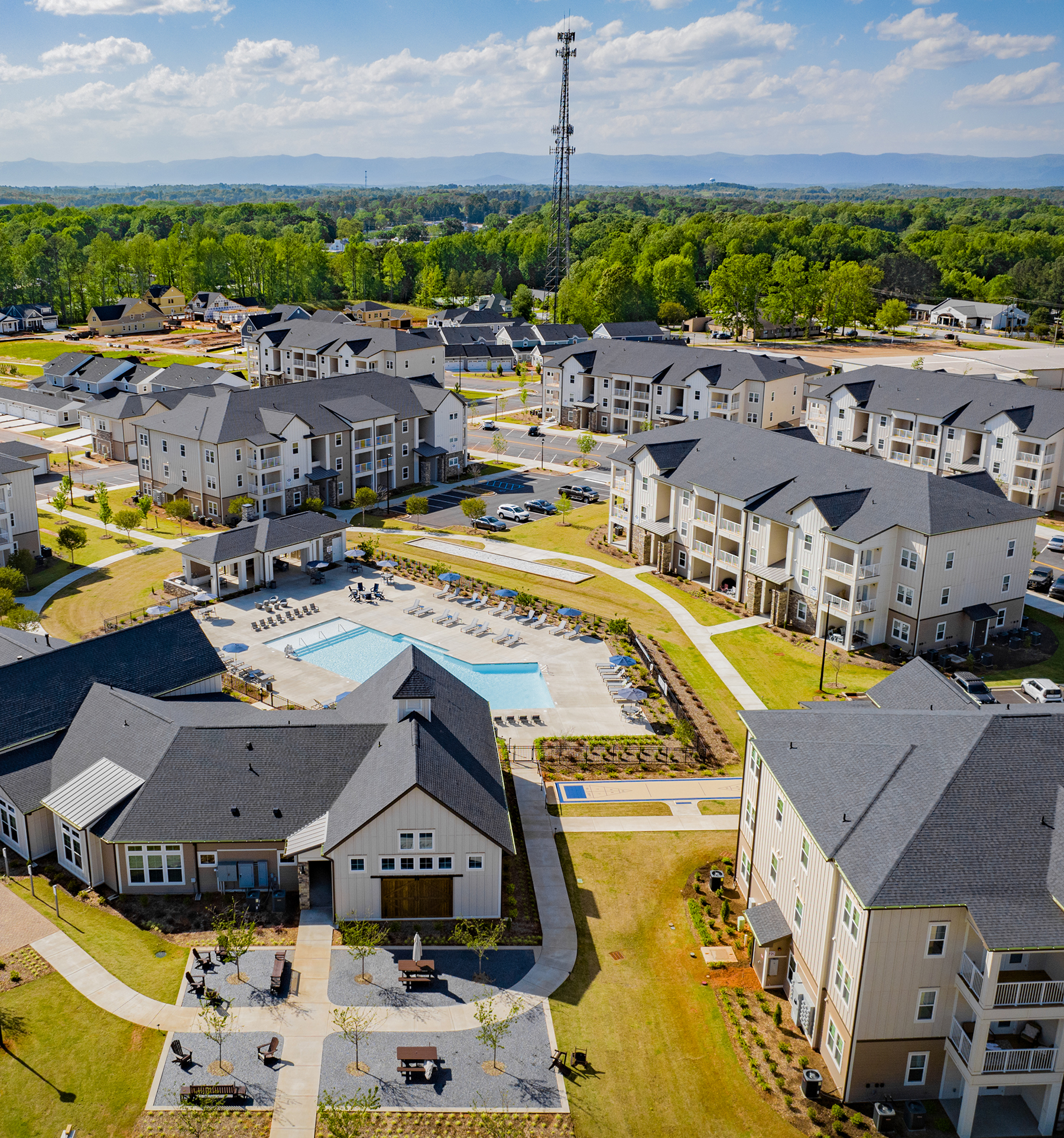 aerial view of a community with houses, apartments and a pool