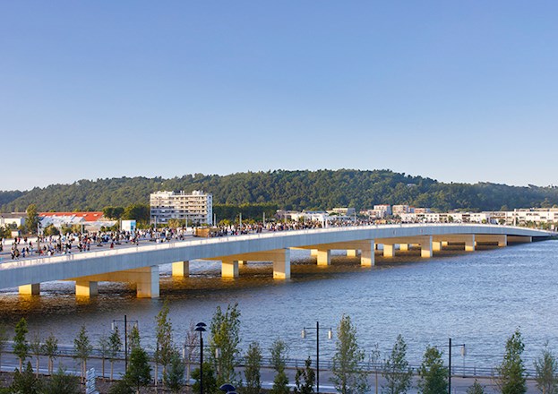 A wide concrete bridge is crowded with people rather than vehicles.