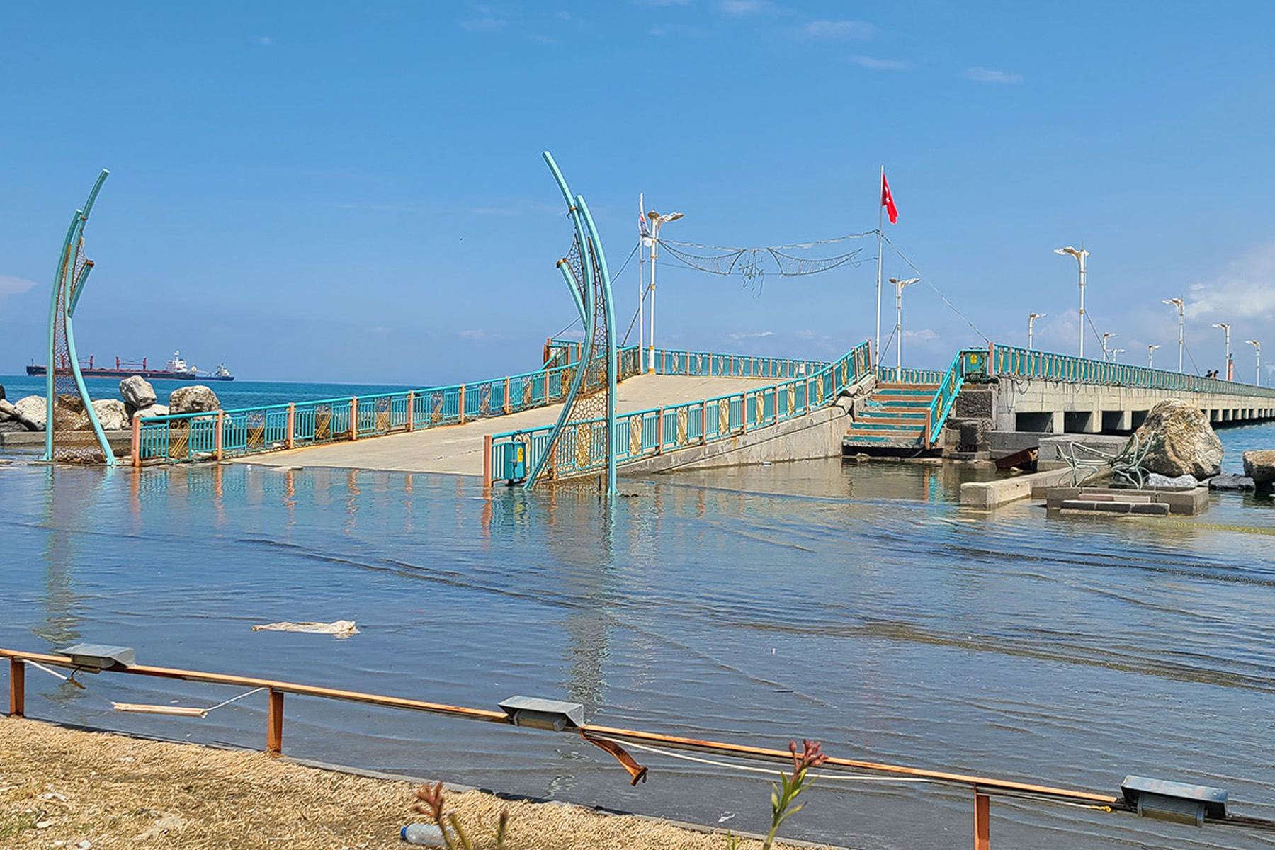 A damaged ferry terminal is partially submerged.