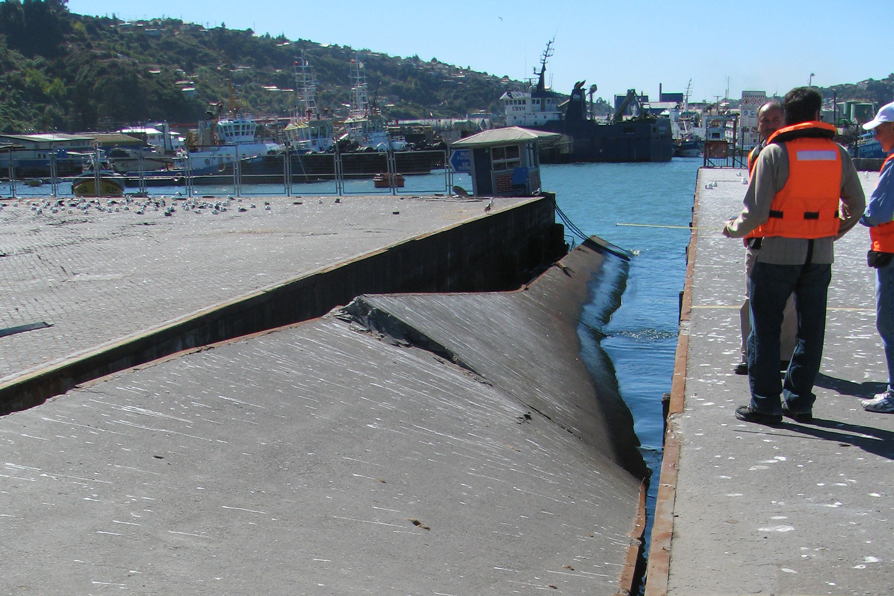 Men inspect a damaged access ramp.