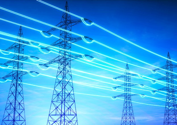 A network of power lines highlighted in blue stretch across an evening sky.