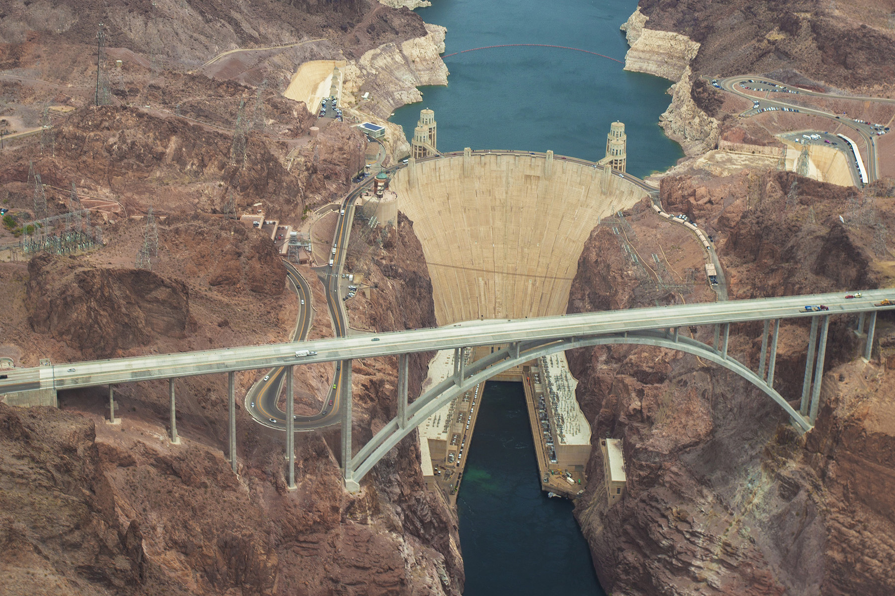 Large stone structure (a dam) impounds a body of water behind it.