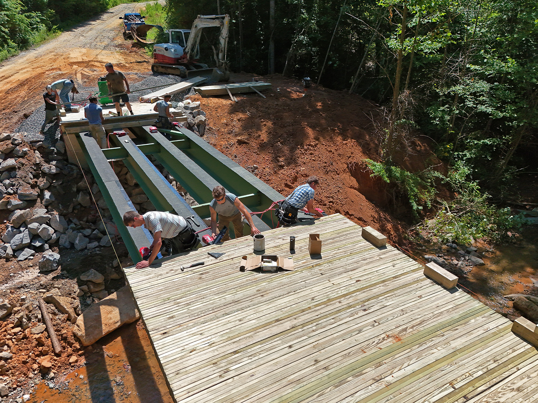 Men are building a new bridge destroyed by a flood. 