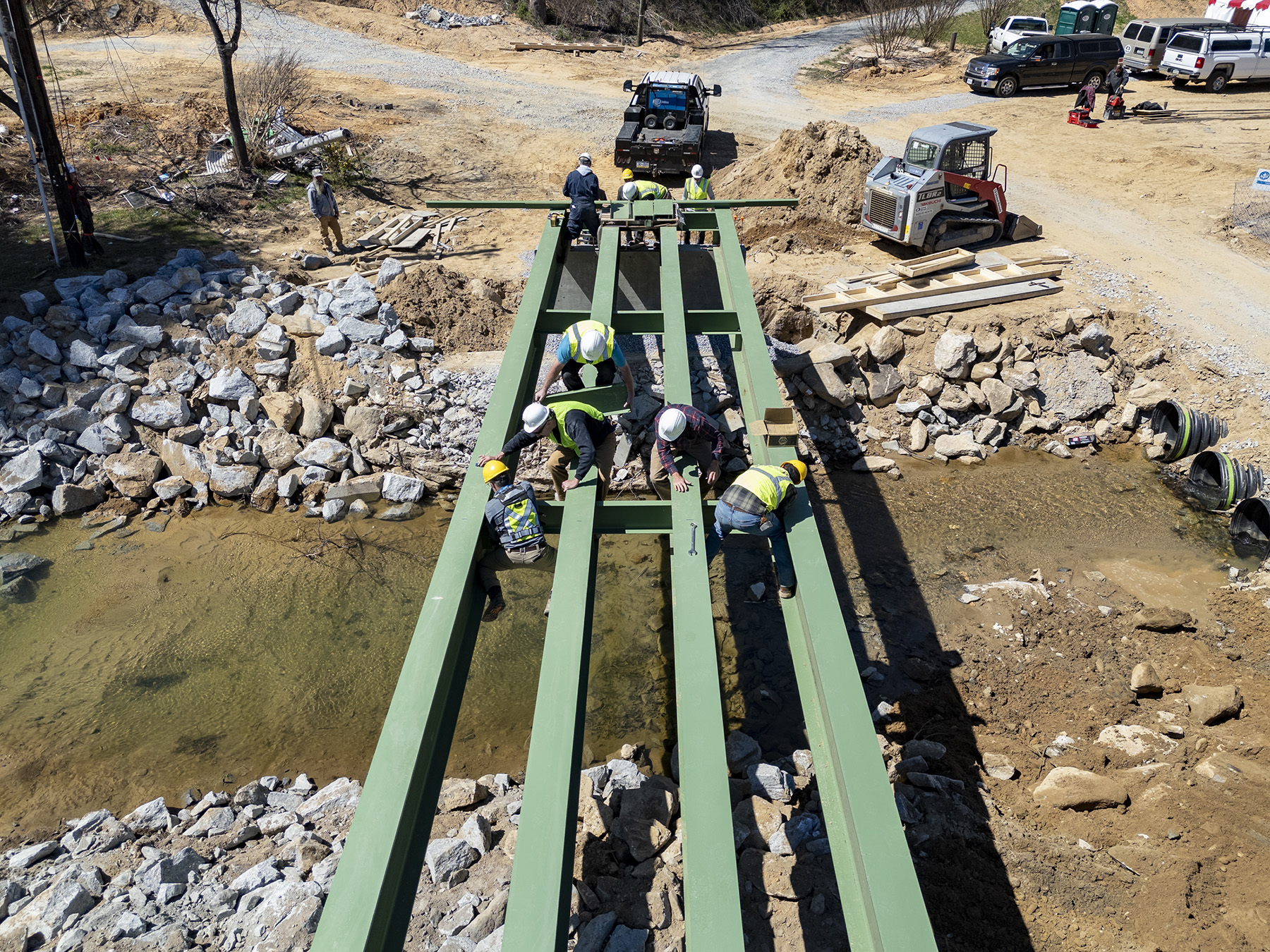 Men are building a new bridge destroyed by a flood. 