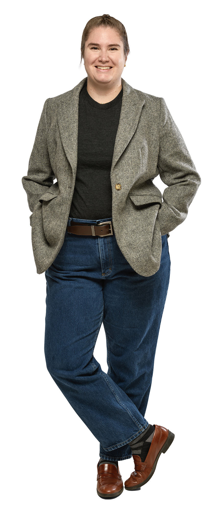 A woman in blue jeans, a black shirt, and jacket smiles at the camera. 