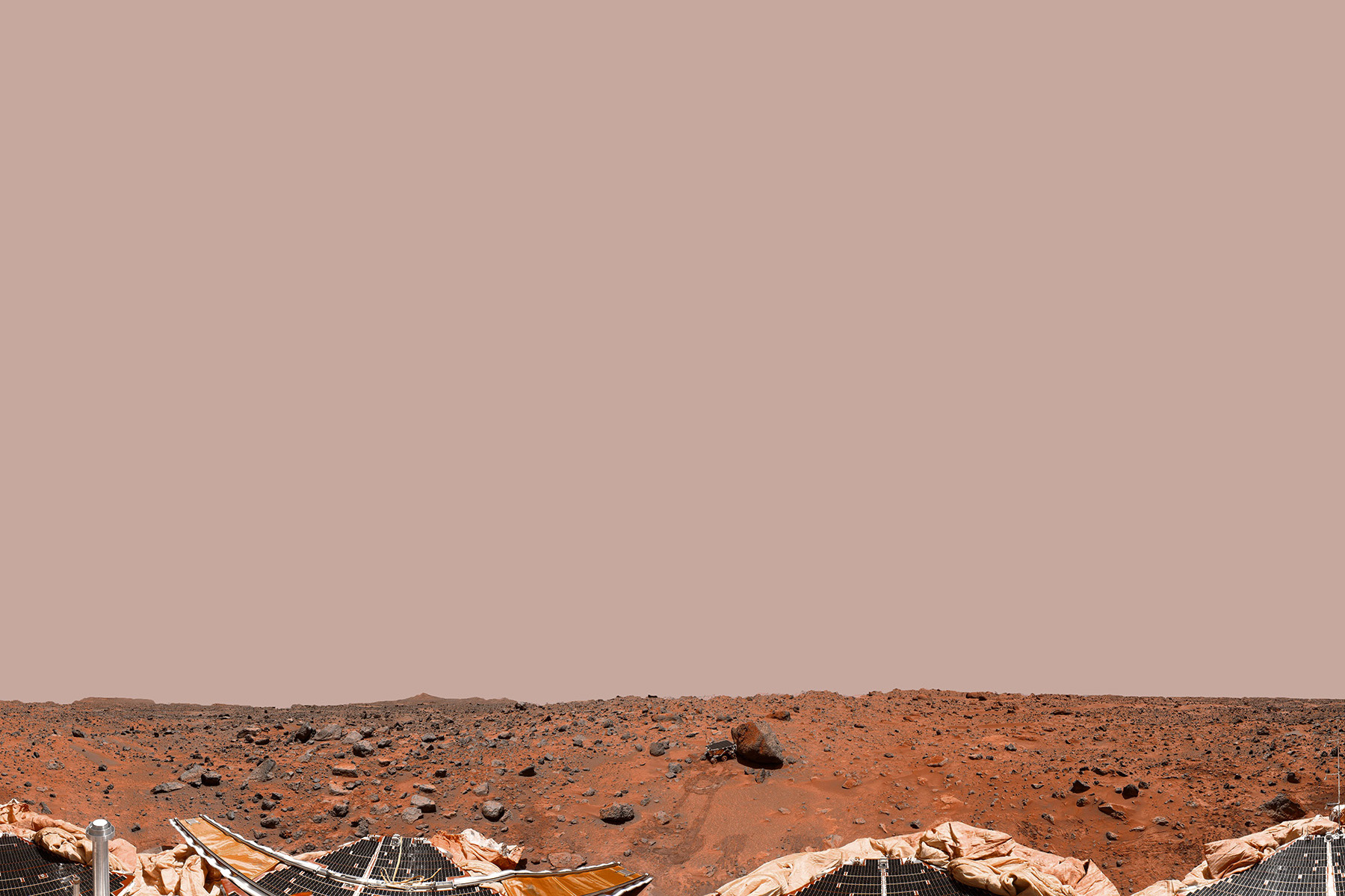 The photograph shows a panorama of Martian regolith with parts of the NASA lander visible at the bottom. 