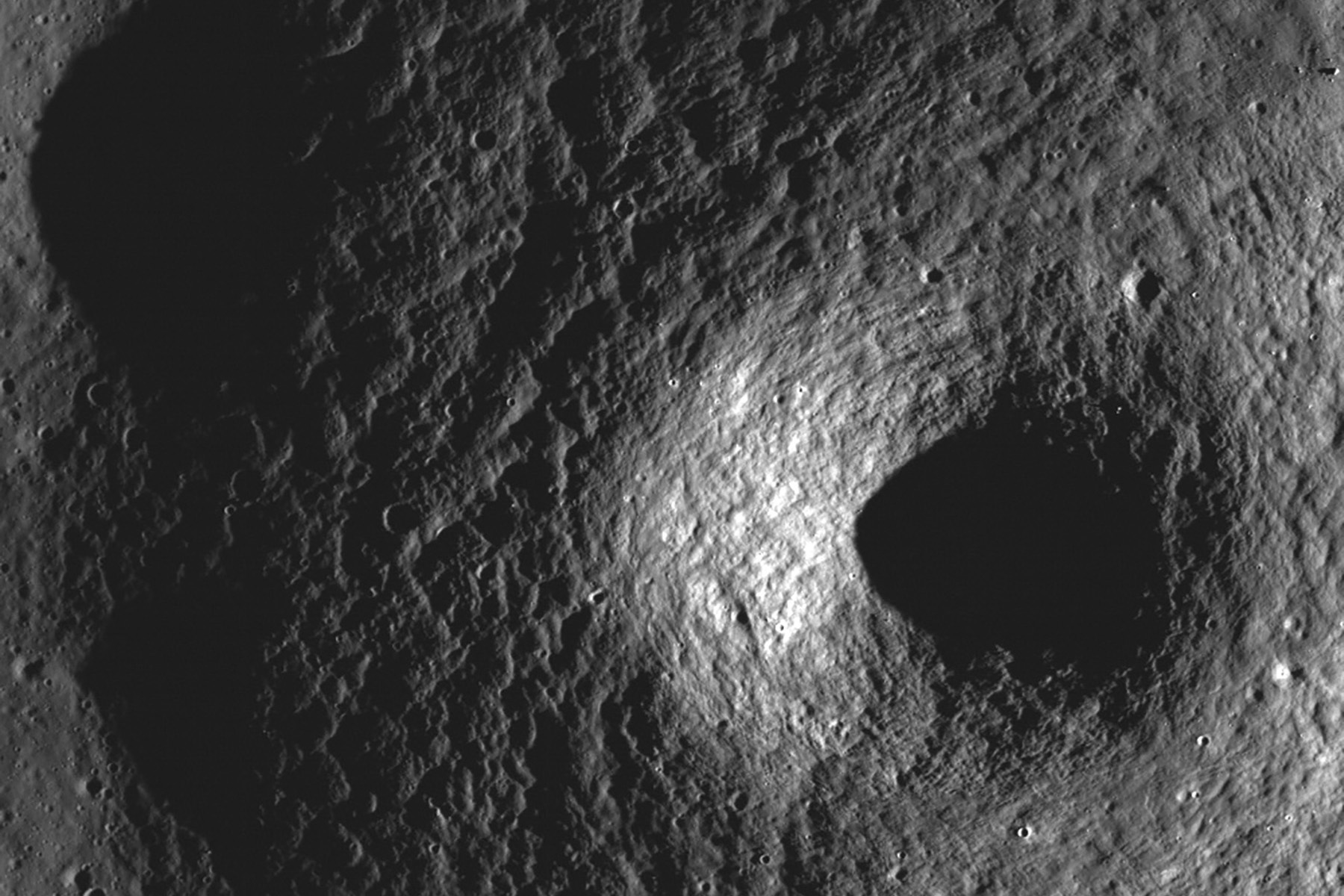 A photo shows a closeup of a crater on the moon. 