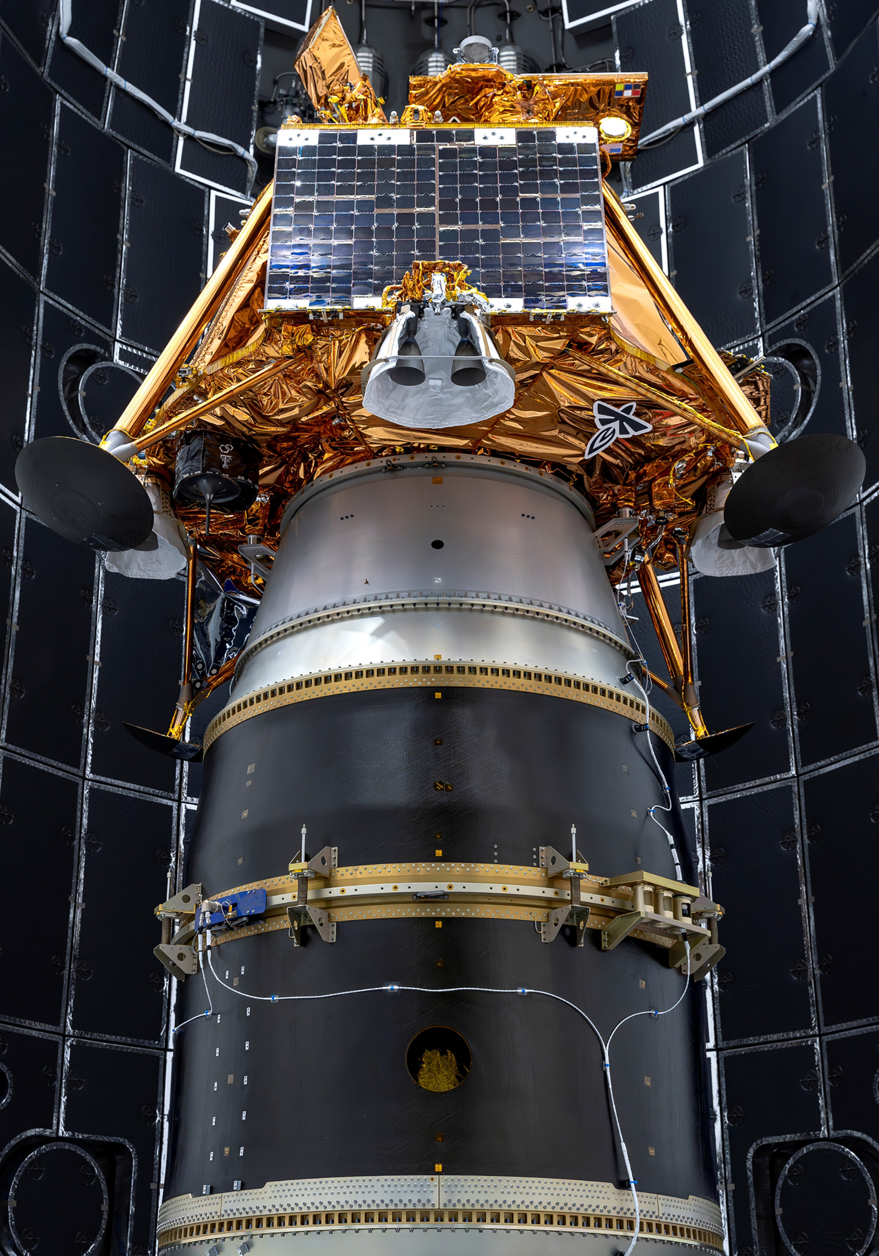 A stationery dark blue and silver rocket holds the square-shaped gold, shimmering LISTER system.