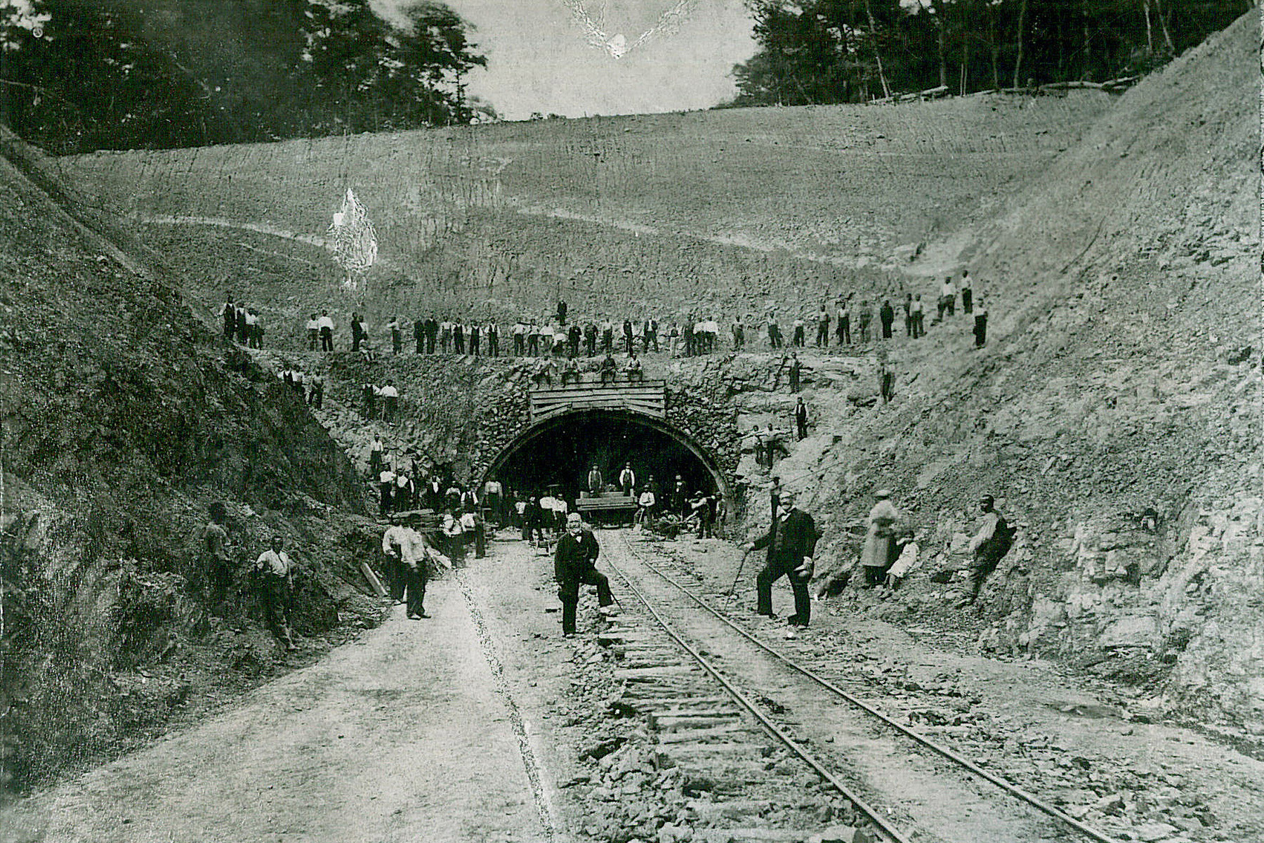 Men are pictured in front of the entrance to a tunnel that they’re digging out. 