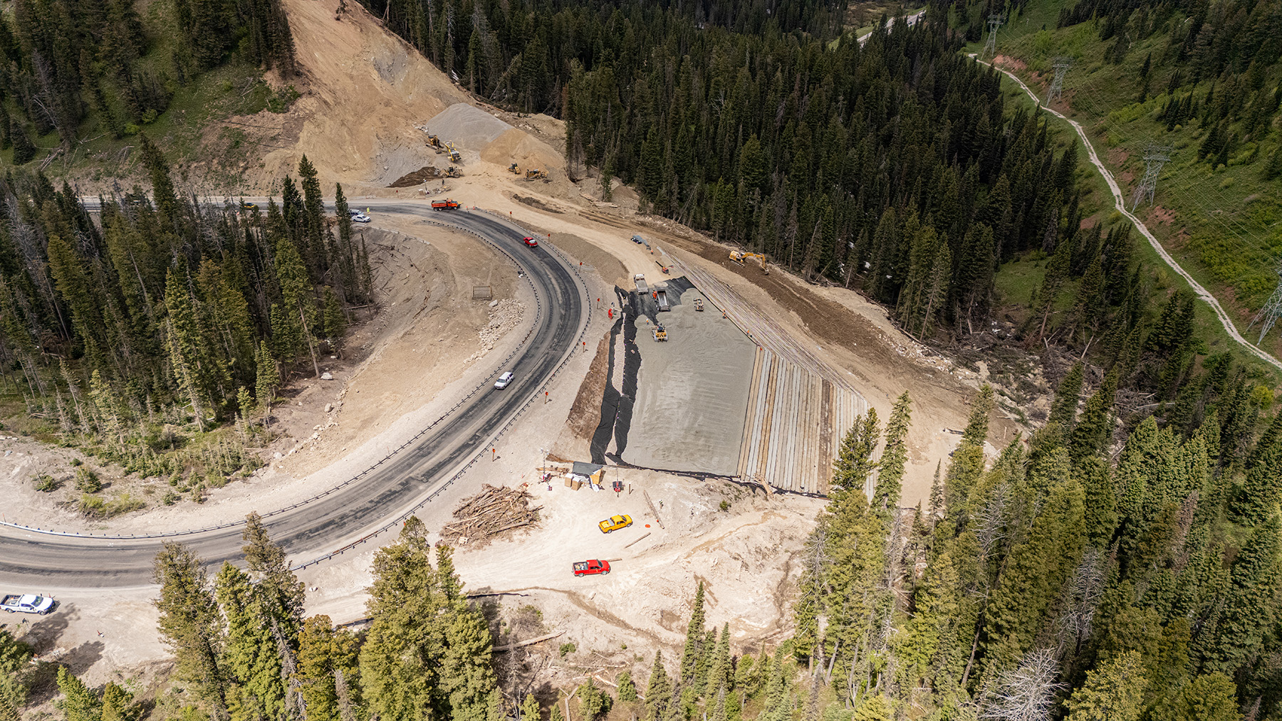 Aerial view of a semicircular roadway detour and construction of an earthen embankment. 