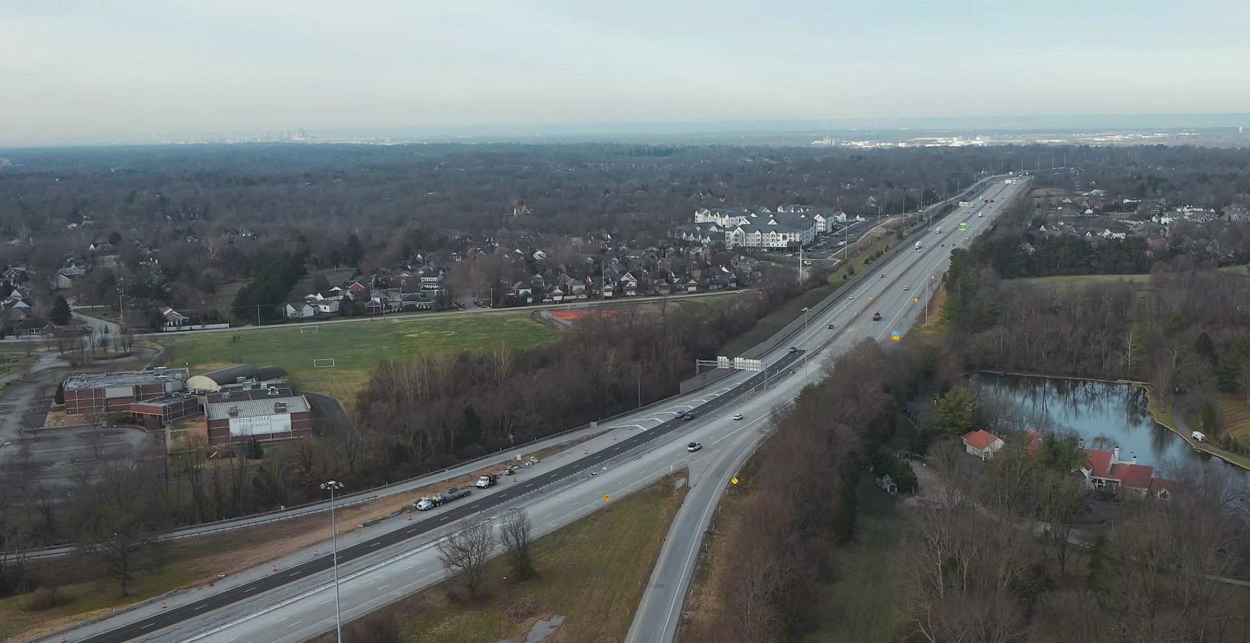 The photo shows a multilane highway set amidst a city. There are roads branching off the main highway drag. 