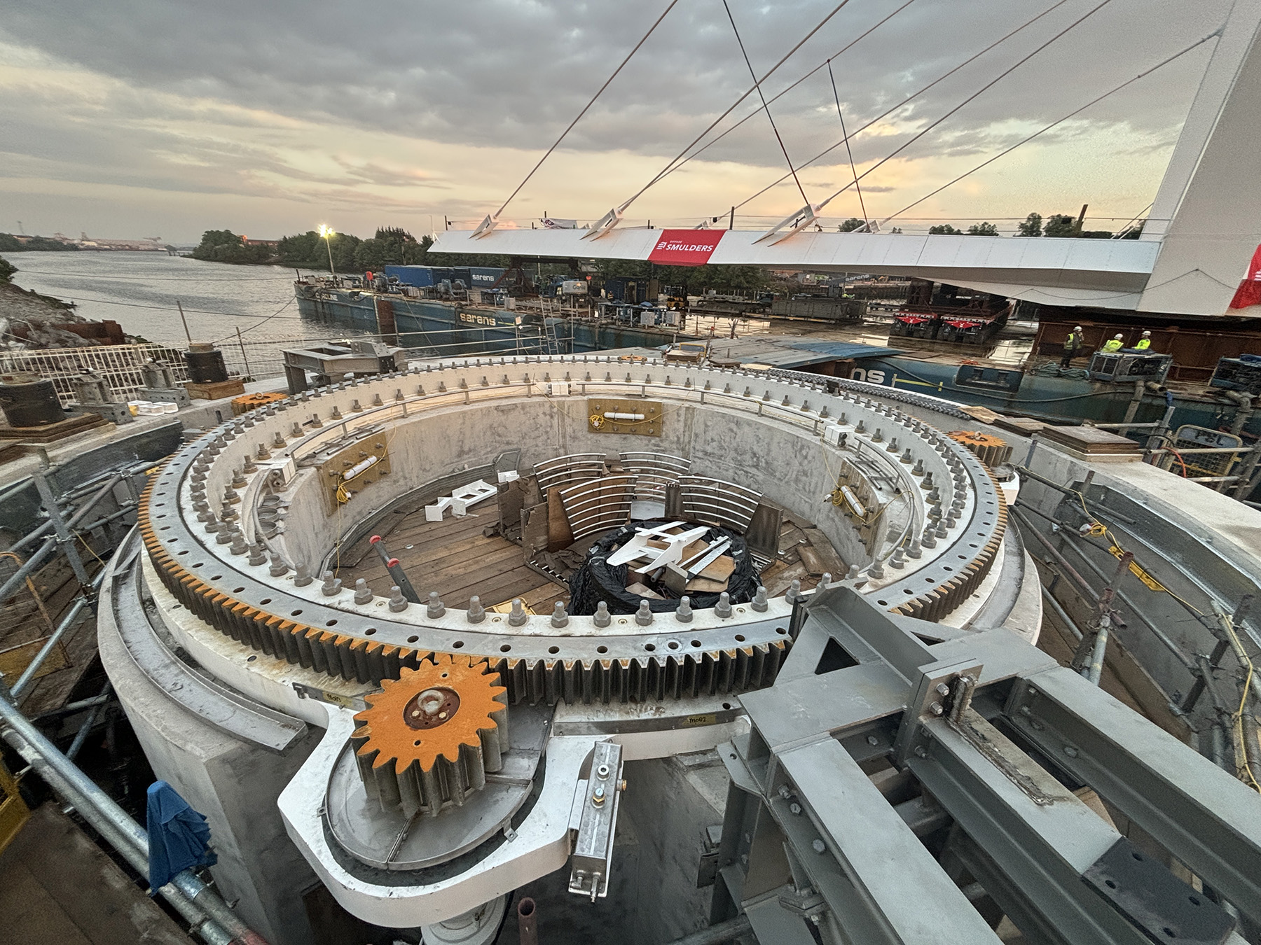 The photograph shows a large, round rack that is part of the mechanism to open and close a swing-span bridge.