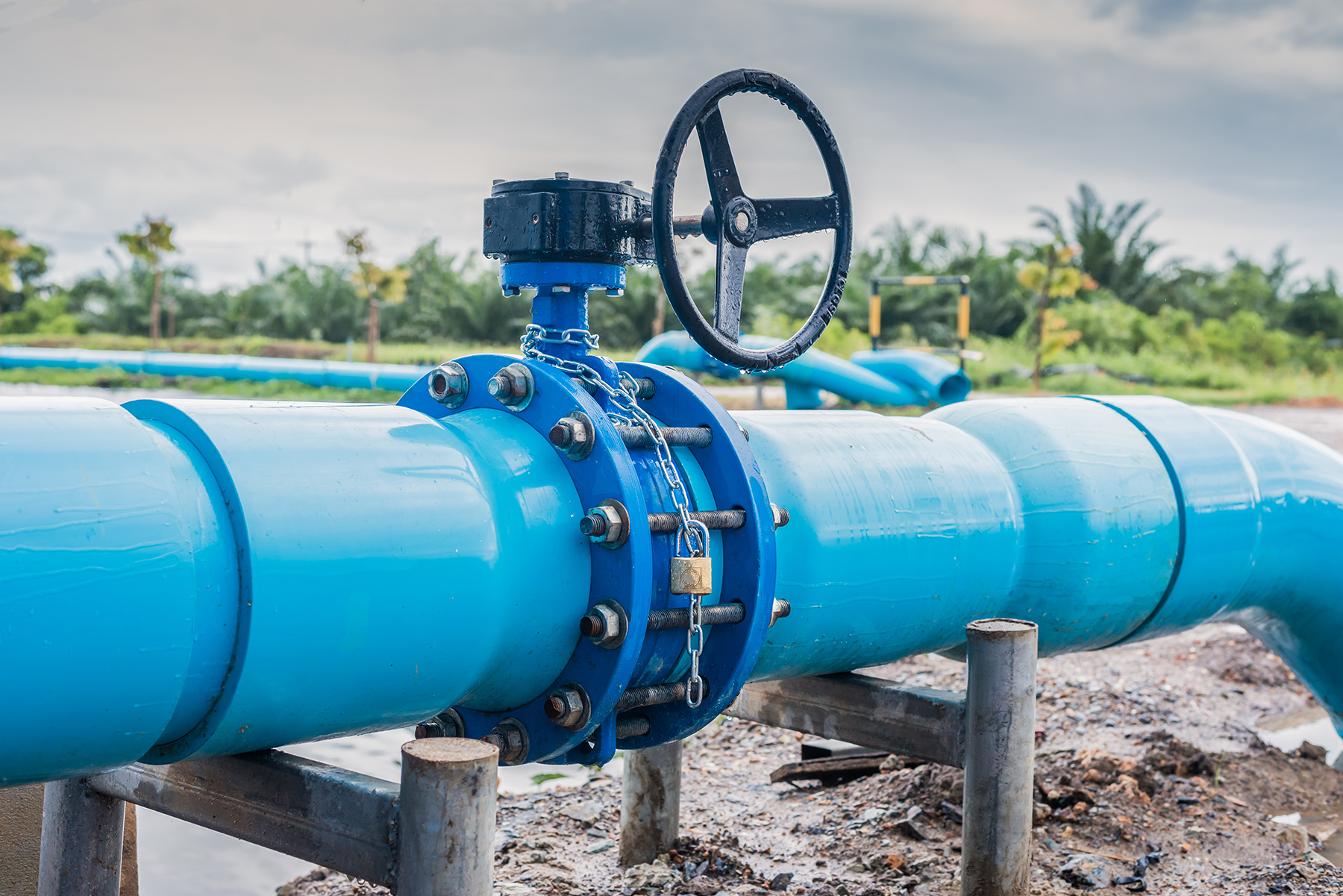 Image shows a blue water main pipe that has a valve at one of its junctions.