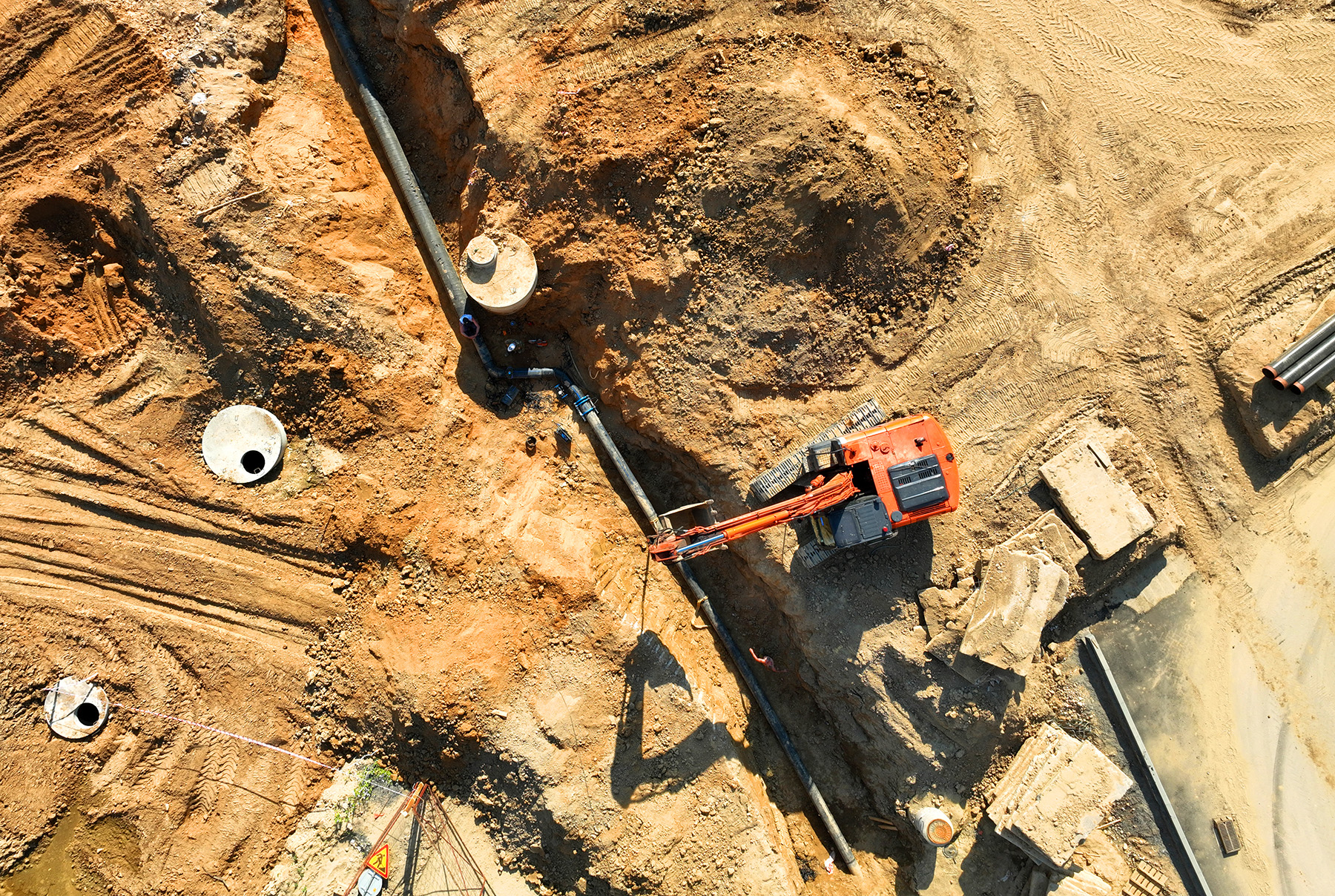 Photo shows the installation of a sewage drainage system at construction site. 