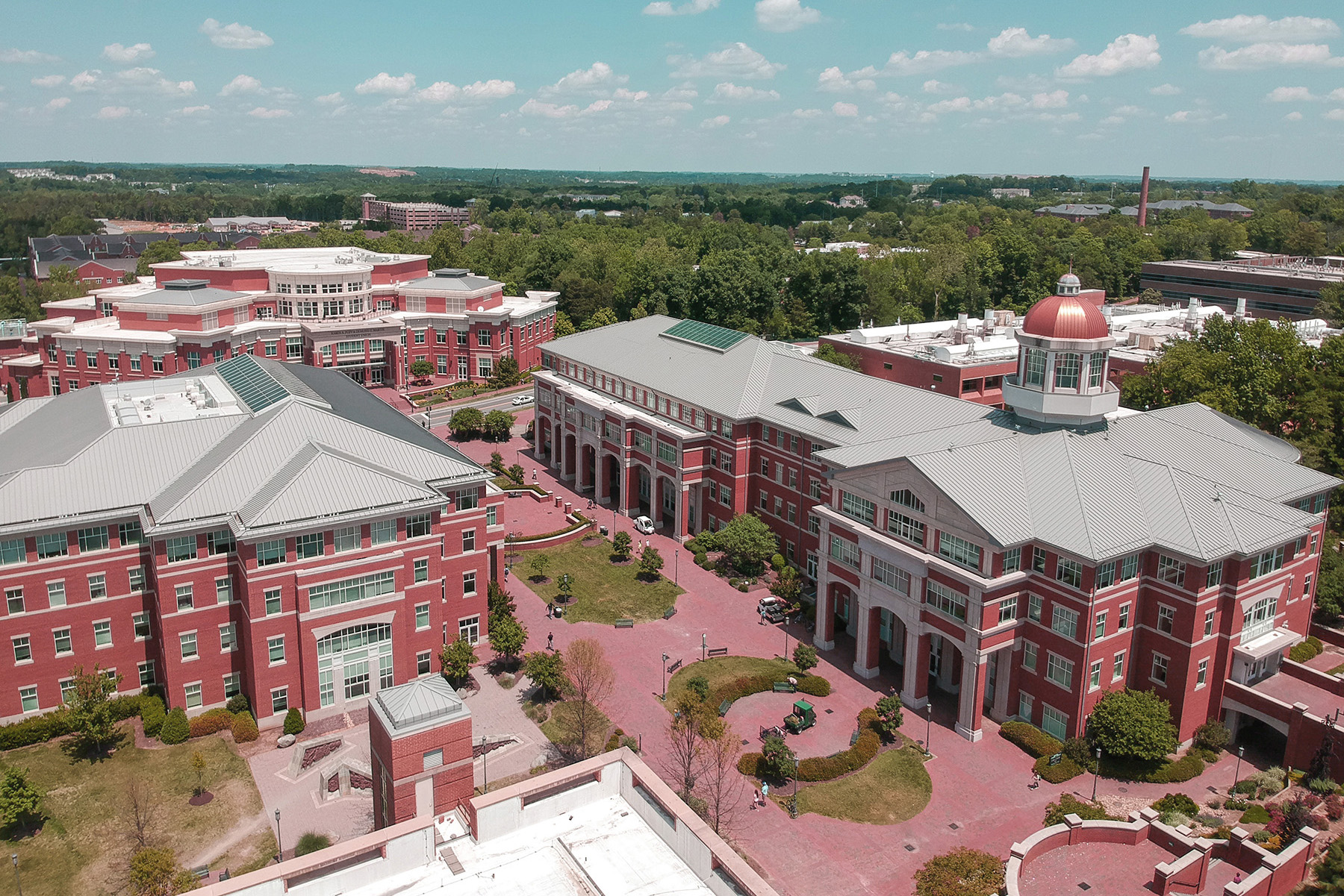 An aerial photograph shows major red-brick academic buildings at UNC Charlotte. 