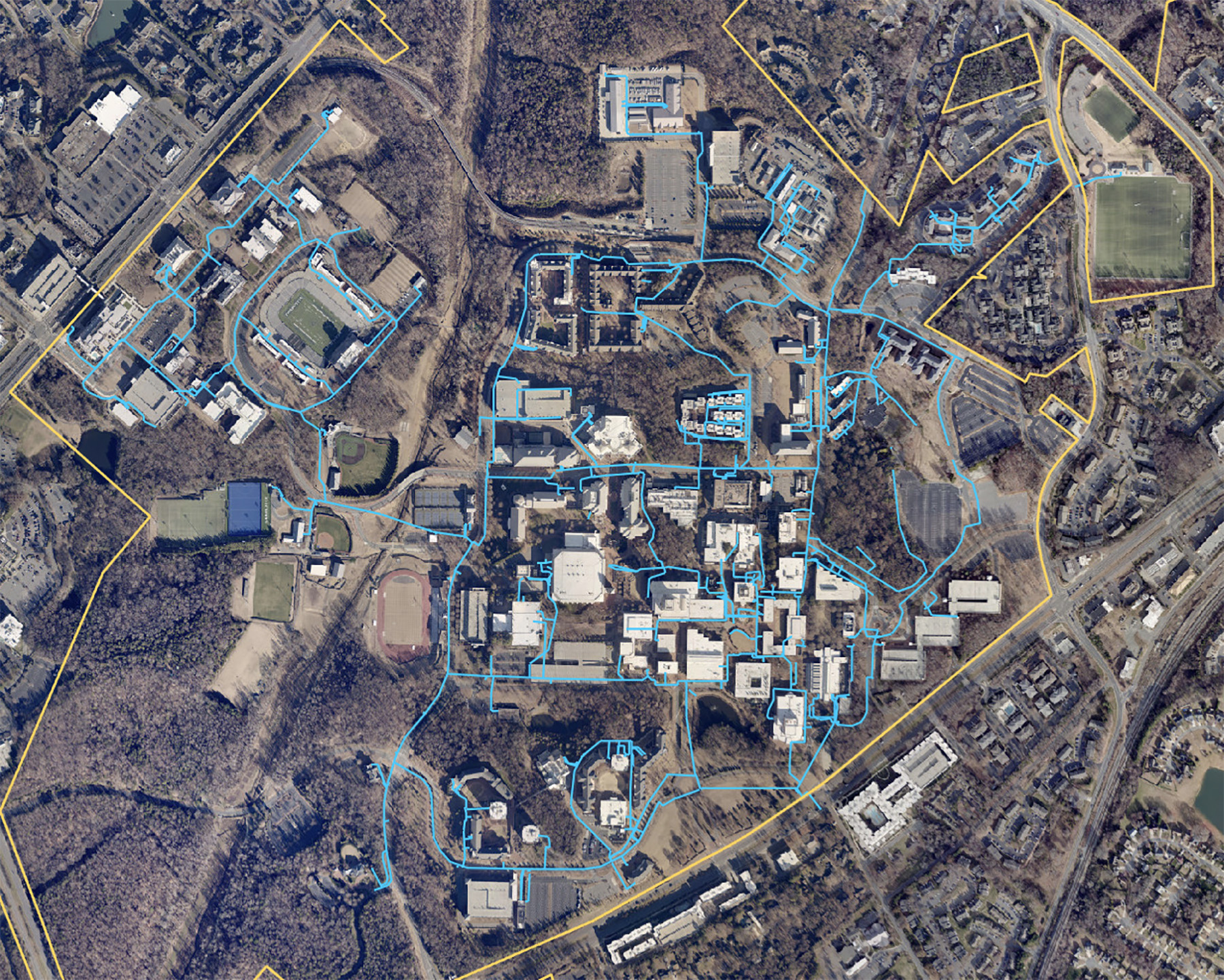 A digital aerial view of the overall campus site is overlaid with blue lines that show the location of the water distribution system network.