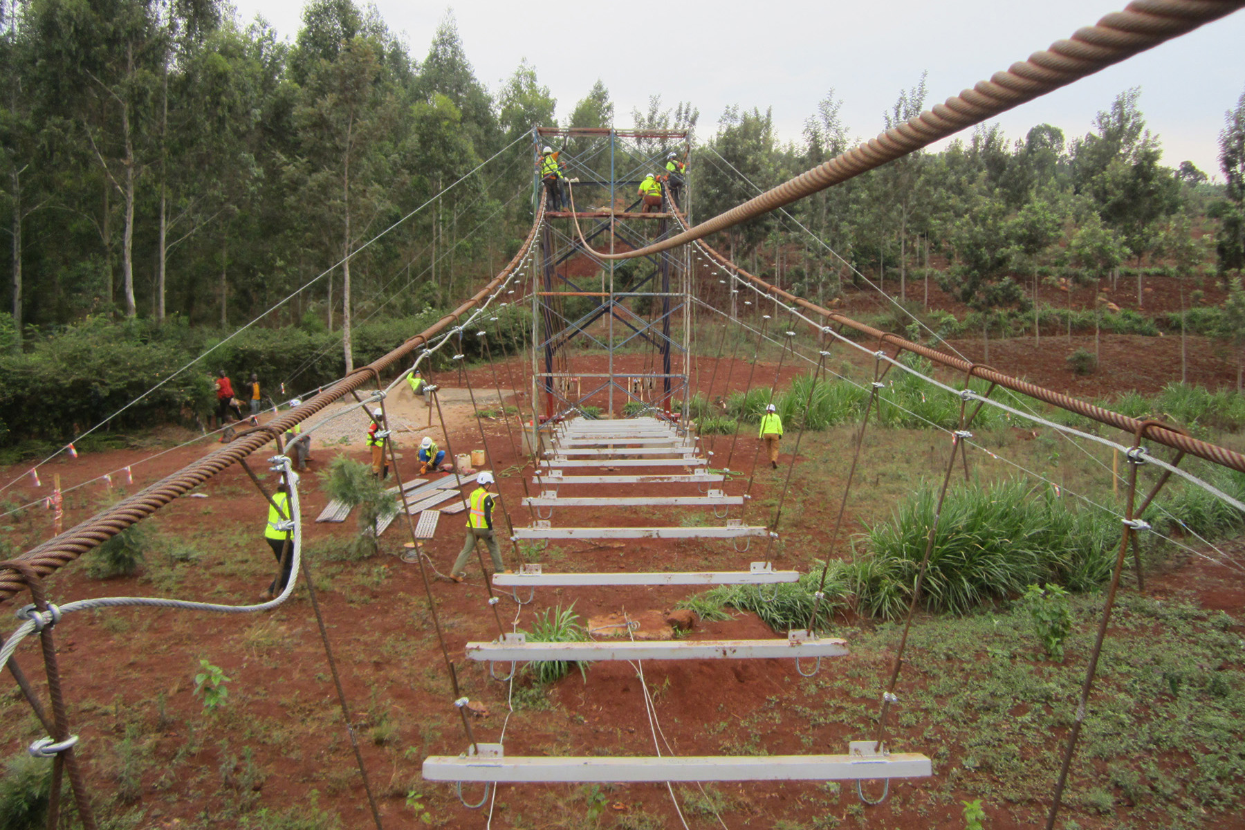 Cables and supporting planks for the deck are being installed.