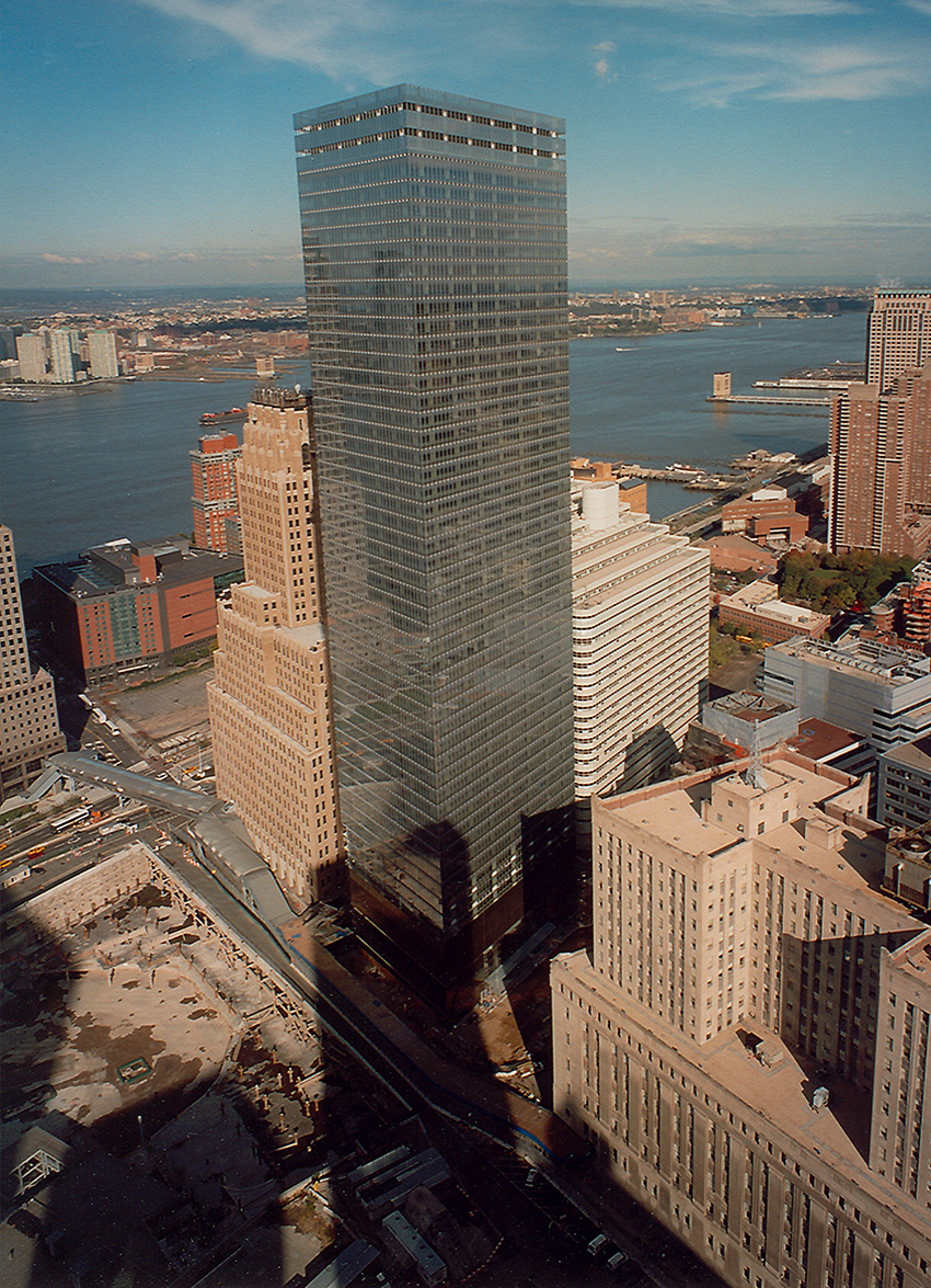 Photograph shows a supertall building surrounded by other tall buildings. 