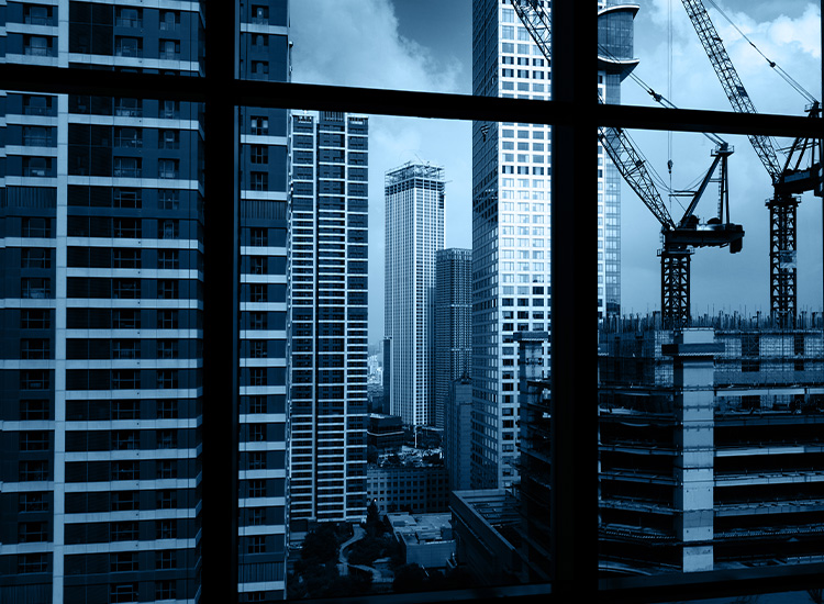 Photograph shows a building under construction in the foreground. In the background are other tall buildings already completed. 