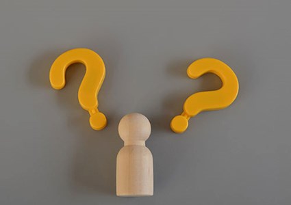 Wooden figure and question mark symbols