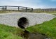 Circular stormwater culvert or drainage pipe passing under a scenic rural road 