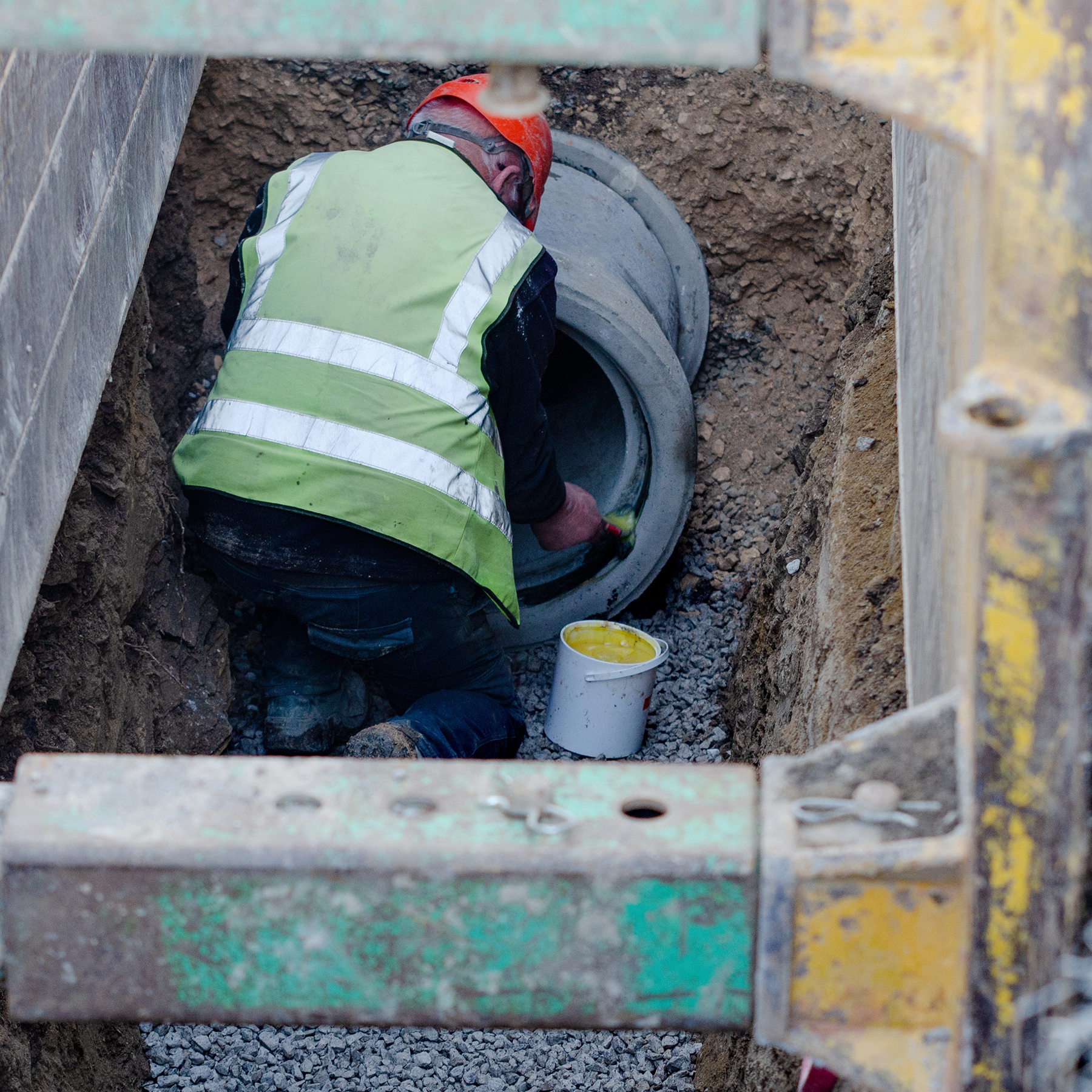 man works to install a concrete pipe underground