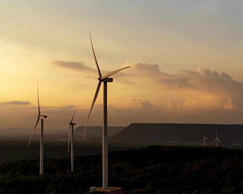 Windmill farm on mountain with sunset sky