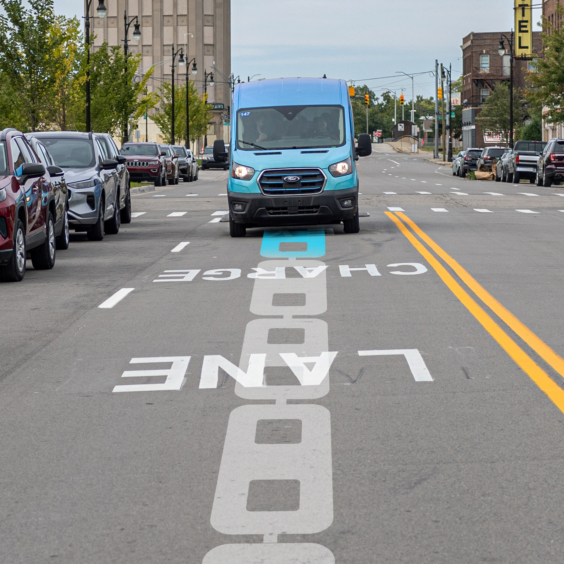 blue van drives along a street