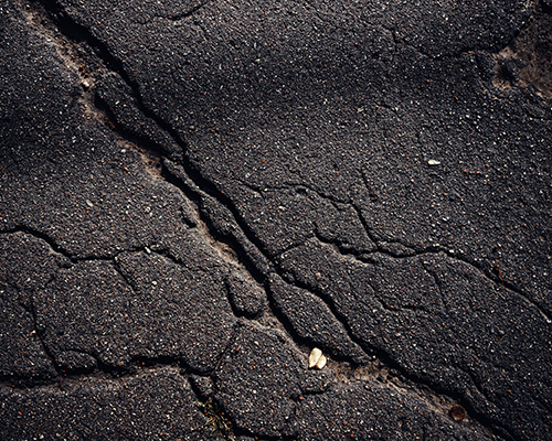 Closeup of cracked asphalt road