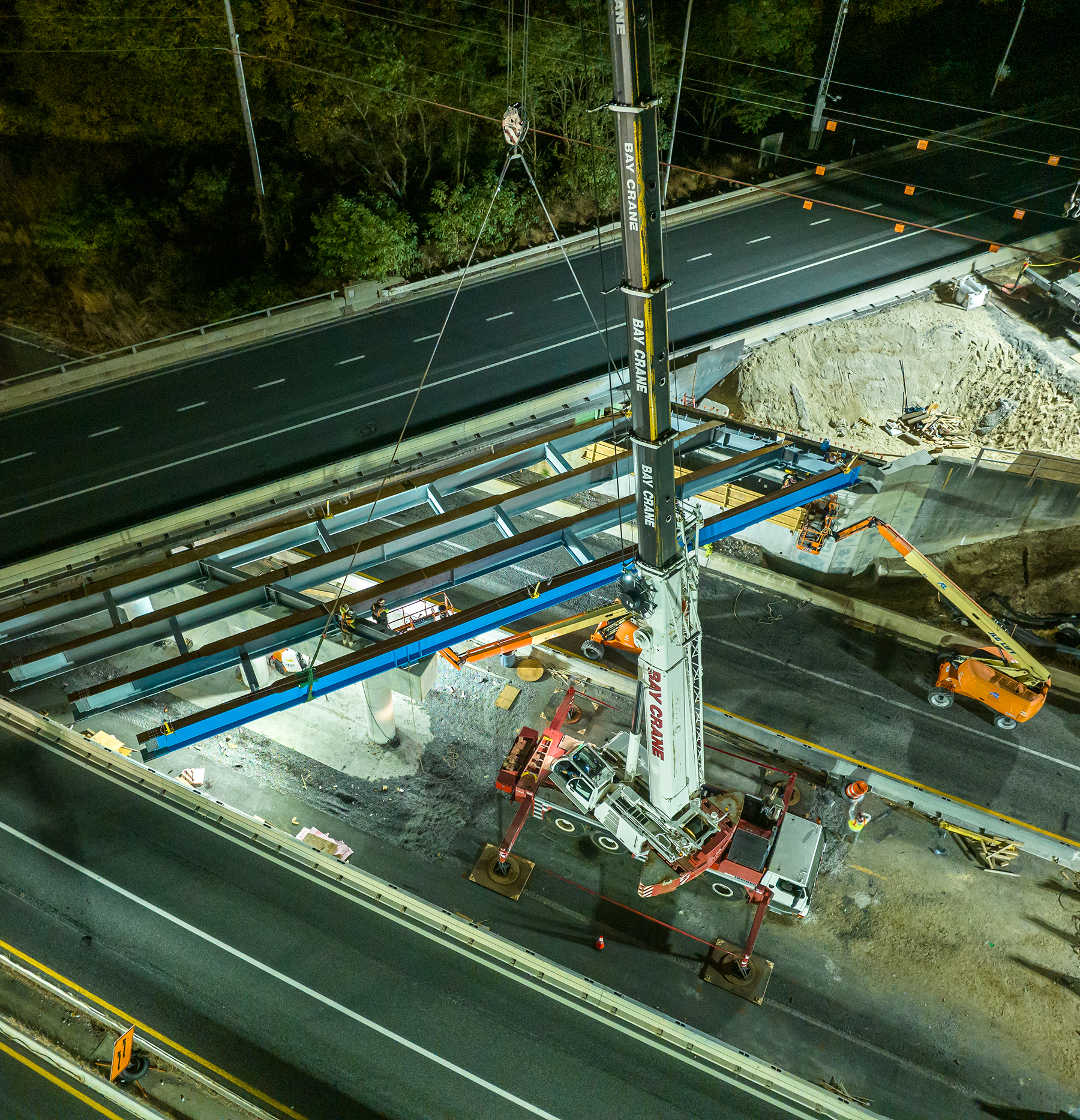 cranes work on a highway project at nighttime cranes work on a highway project at nighttime