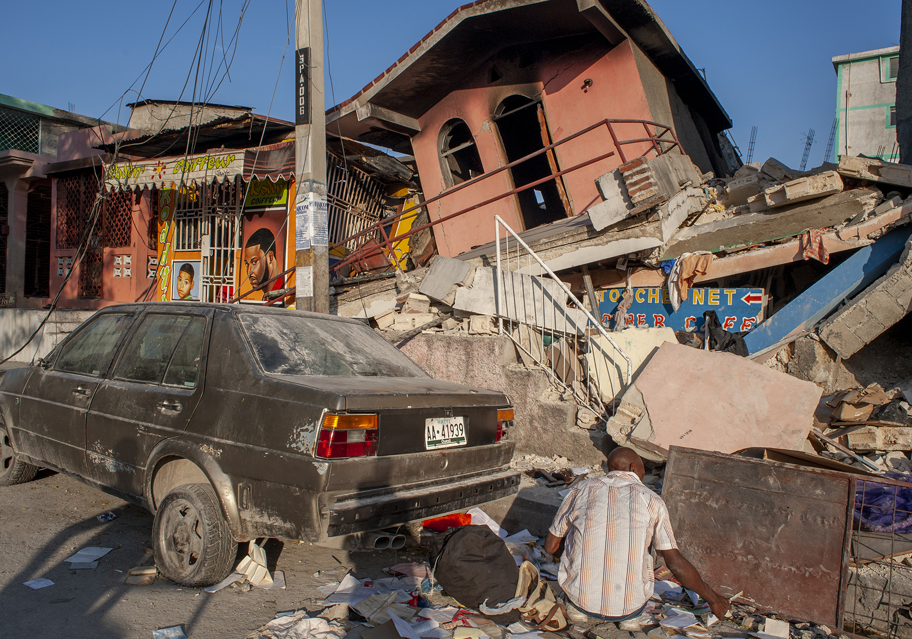 a man sits among earthquake devastation a man sits among earthquake devastation