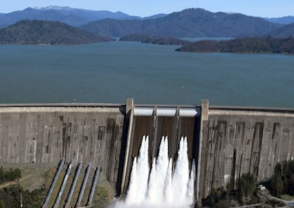 picture from a distance of a dam with mountains in the background