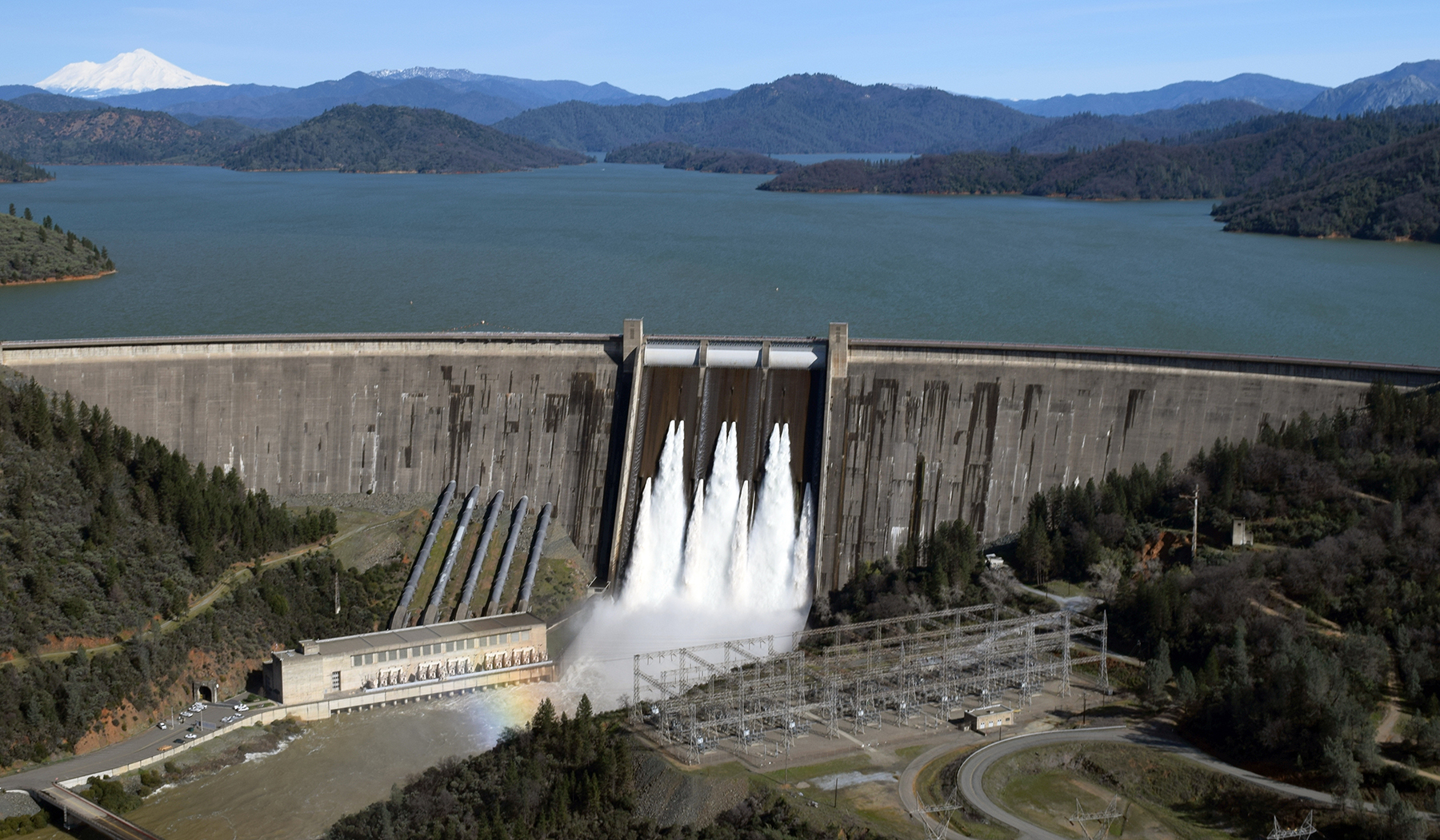 distant photo of dam with mountains in the background distant photo of dam with mountains in the background