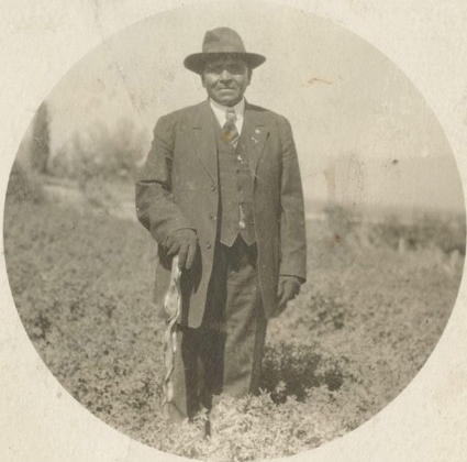 in a black and white image, a man in a suit and hat poses for the camera in a black and white image, a man in a suit and hat poses for the camera